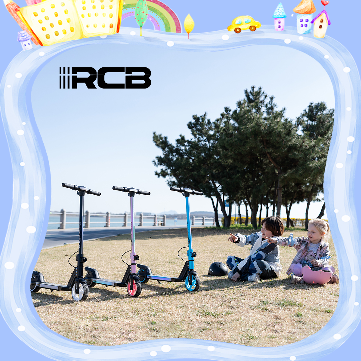 Drei Roller in verschiedenen Farben in der Nähe von zwei Kindern, die im Gras sitzen, unter Bäumen, mit blauem Himmel.