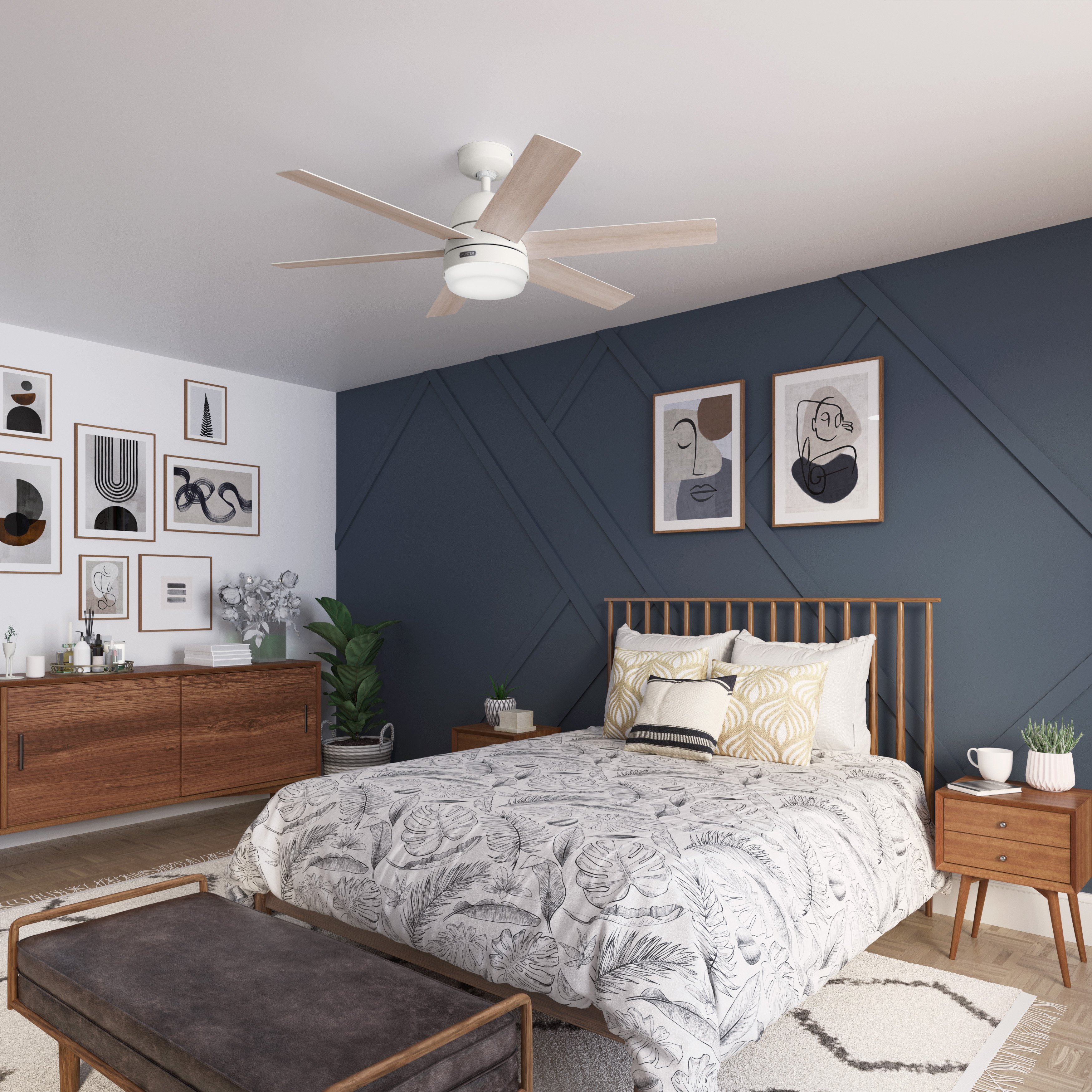 Schlafzimmer mit weißem Deckenventilator, Kunstwerken und Holzmöbeln. Dunkelblaue Akzentwand.