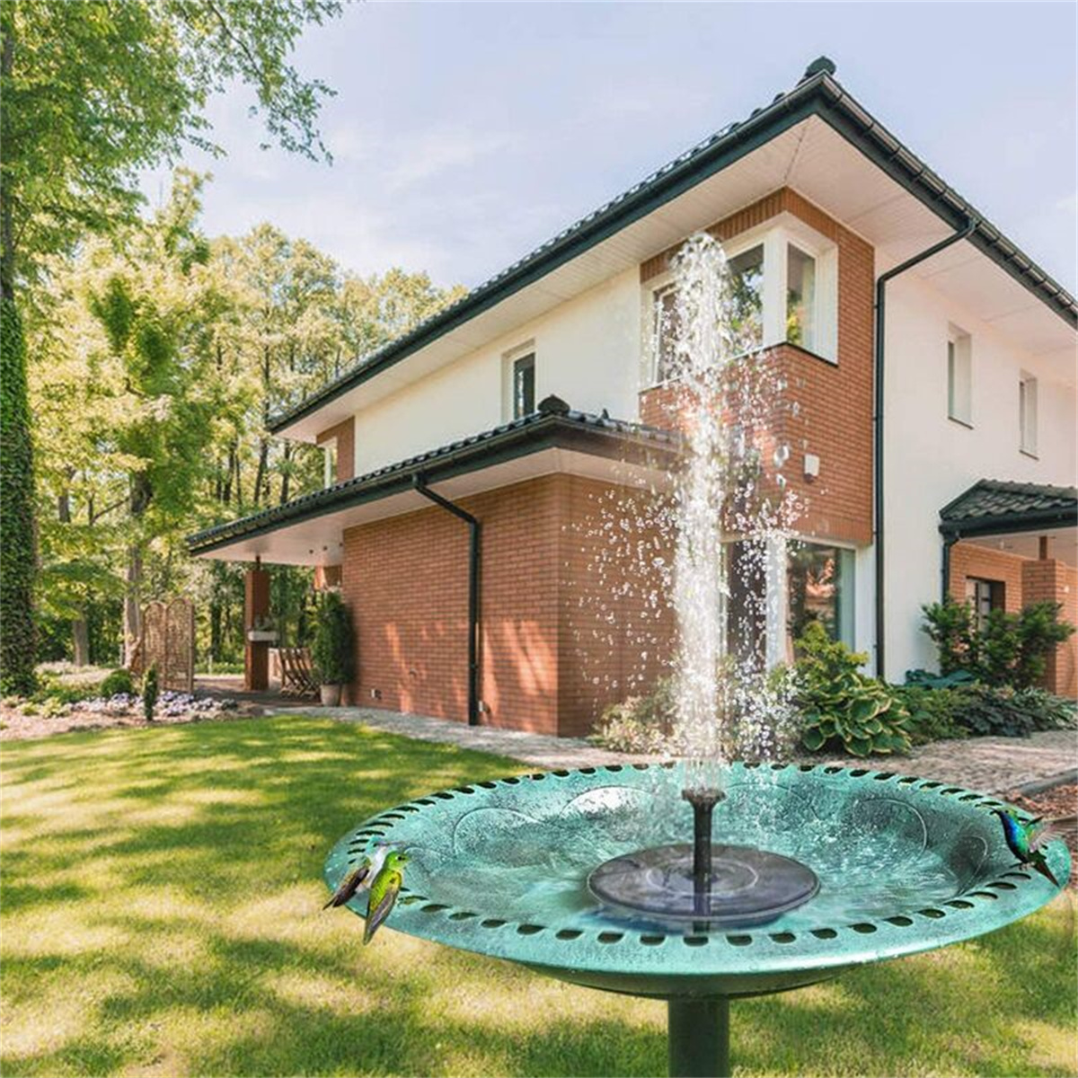 Gartenbrunnen mit Wasserspeier, Vogelbad und Haus im Hintergrund.