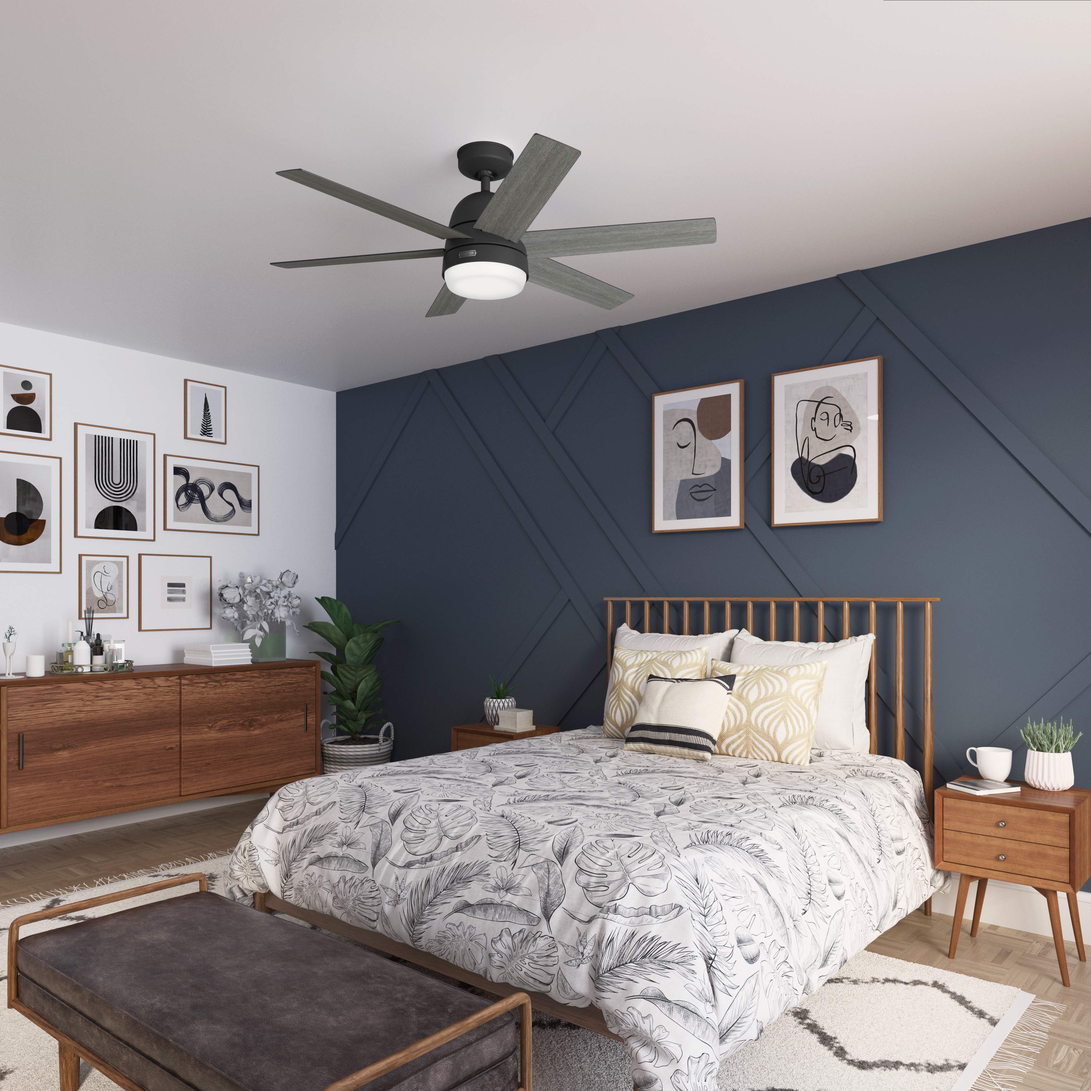 Ein Schlafzimmer mit Bett, Kommode und Deckenventilator. Die Wände sind blau und weiß, mit Bildern.