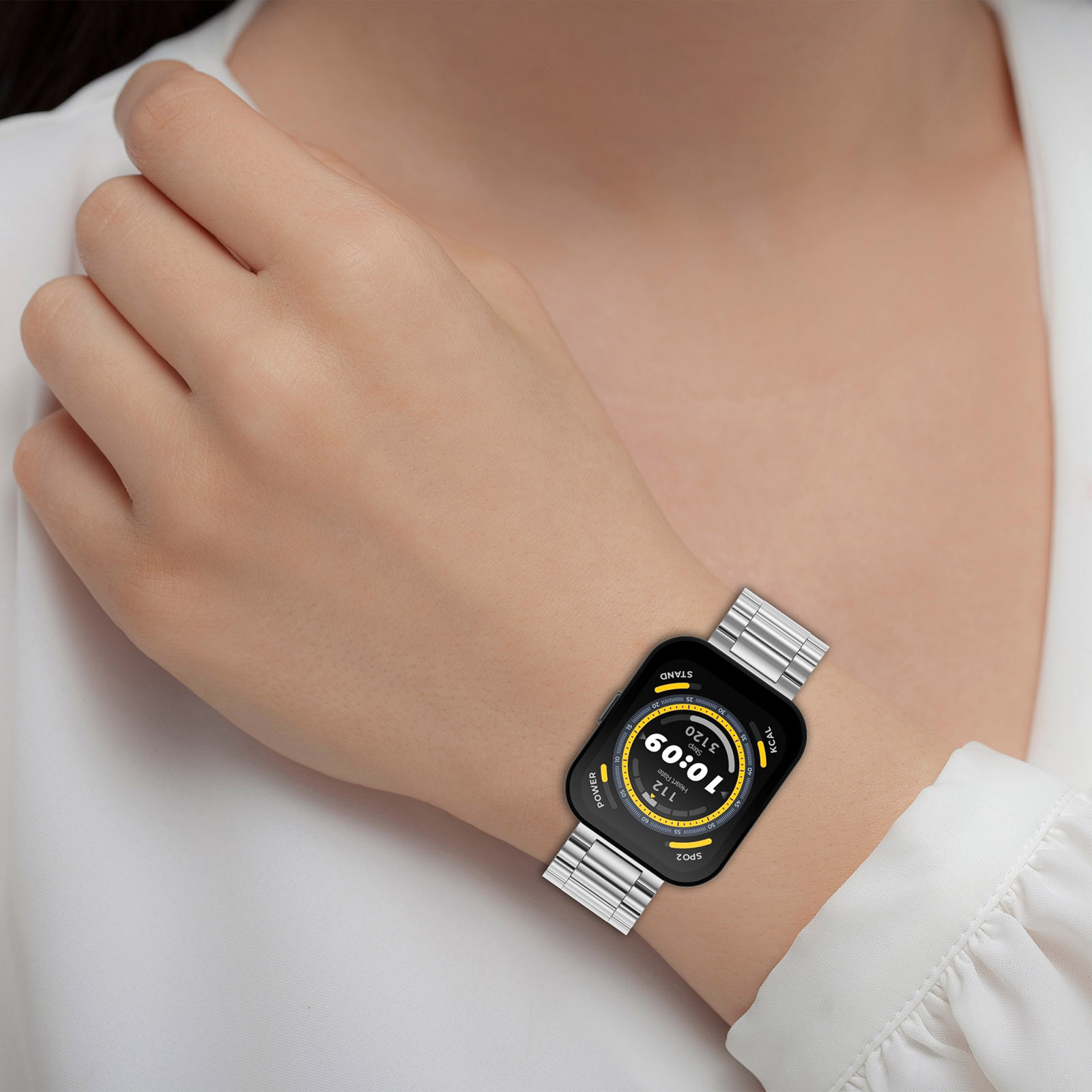 Das Handgelenk einer Person mit einer Smartwatch mit Metallarmband. Der Bildschirm zeigt die Uhrzeit an.