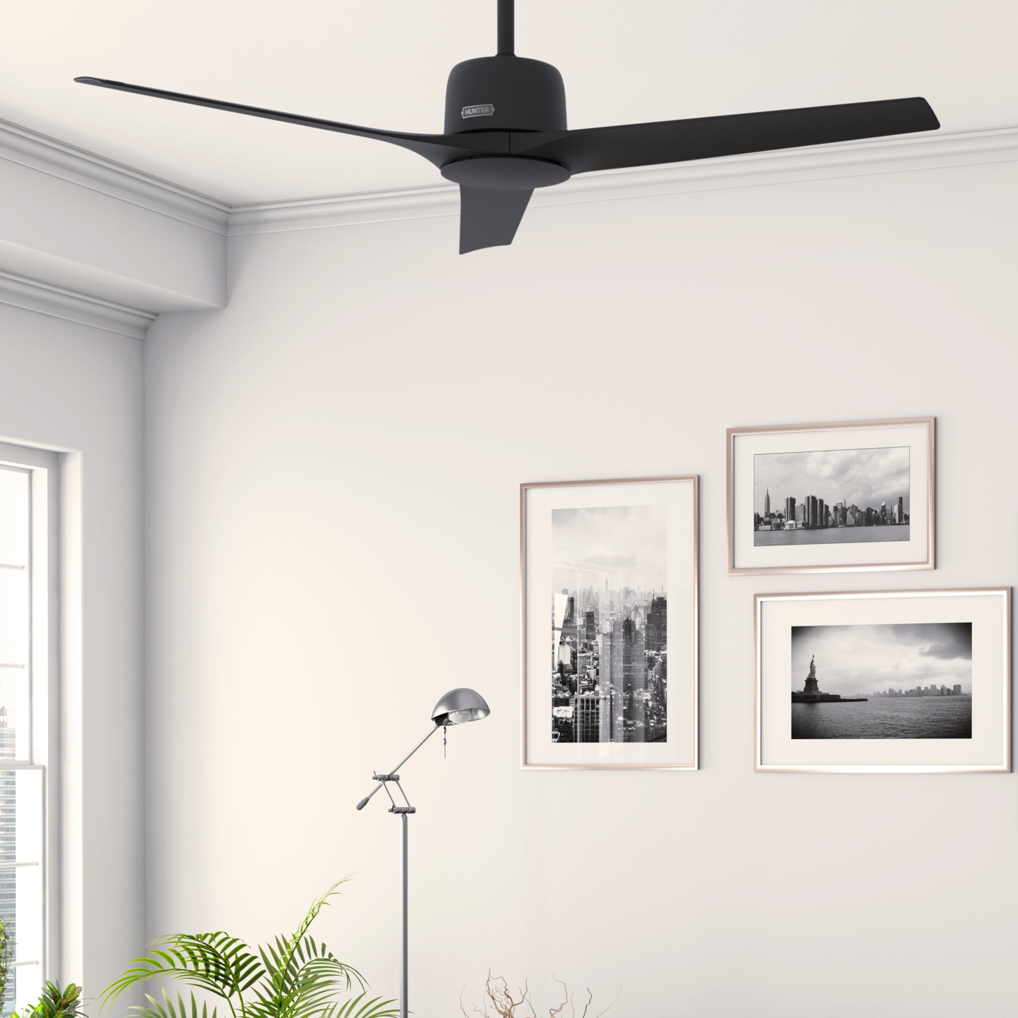 Raum mit weißen Wänden, Deckenventilator und gerahmten Stadtbildern.