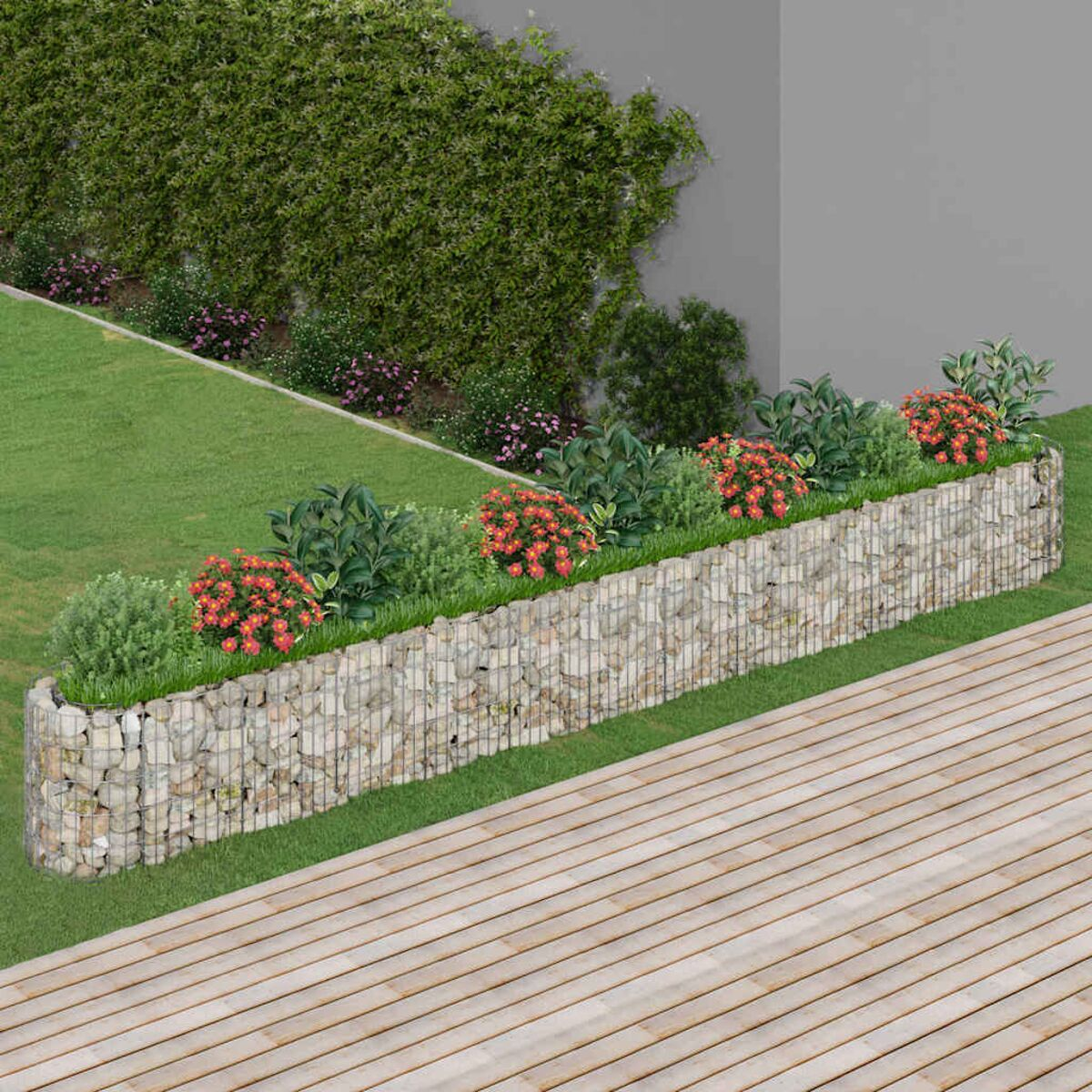Steingabionen-Pflanzgefäß mit grünen Pflanzen und roten Blumen, Holzterrasse und Gras im Hintergrund.