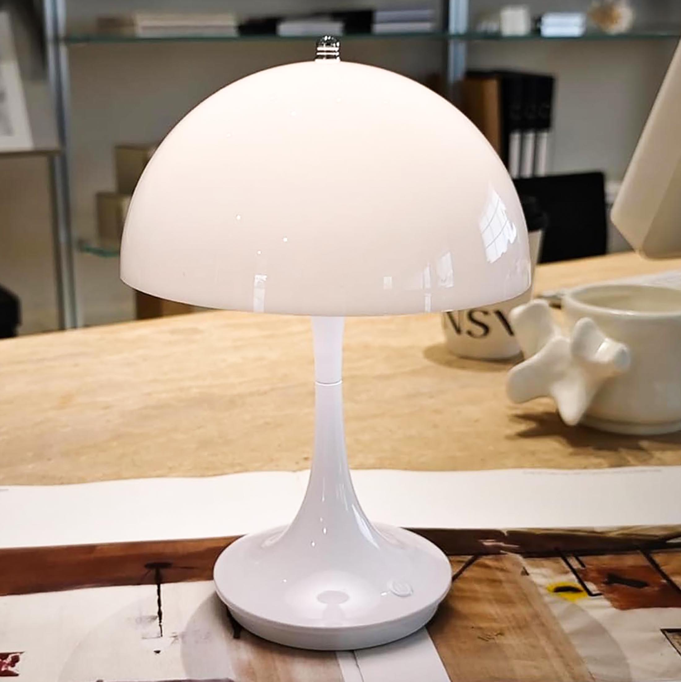Weiße Tischlampe im modernen Stil mit gebogenem Stiel und Sockel.