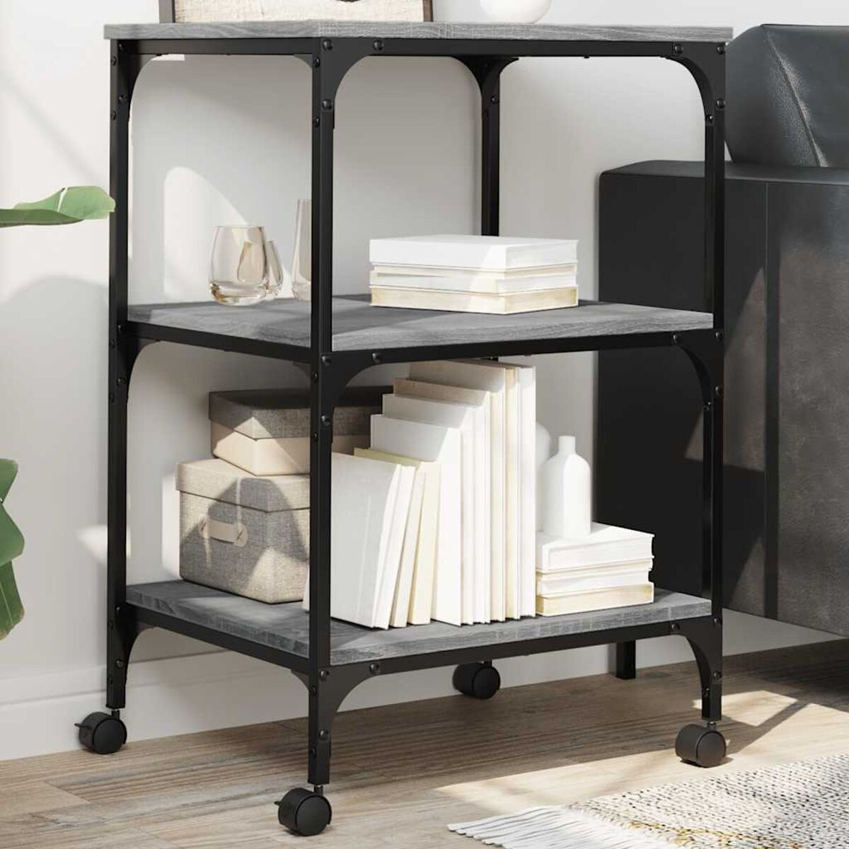 Ein dreistöckiges Regal mit Büchern und Dekoration, mit Rollen, auf neutralem Hintergrund.