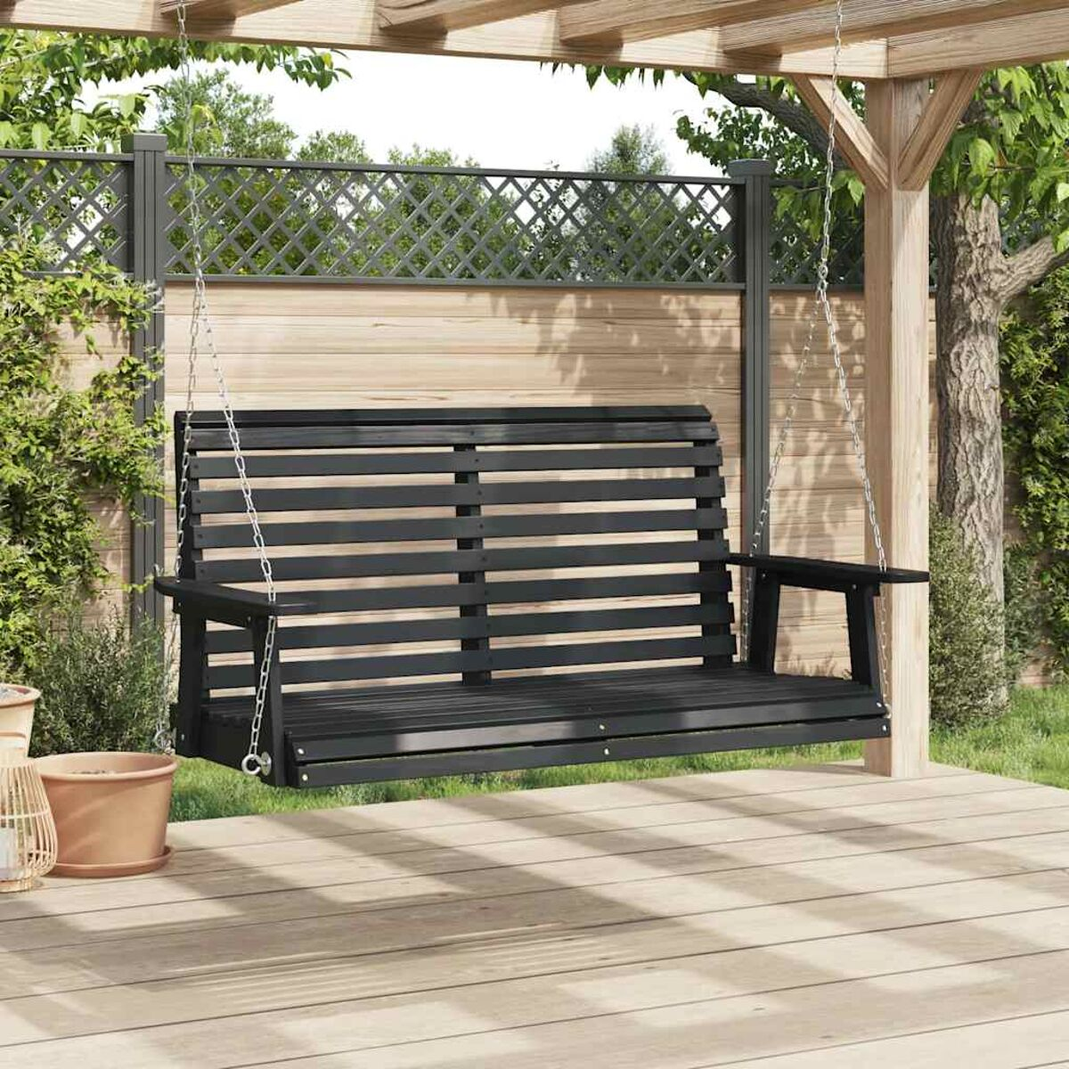 Schwarze Holzschaukel auf einem Holzdeck unter einer Pergola.
