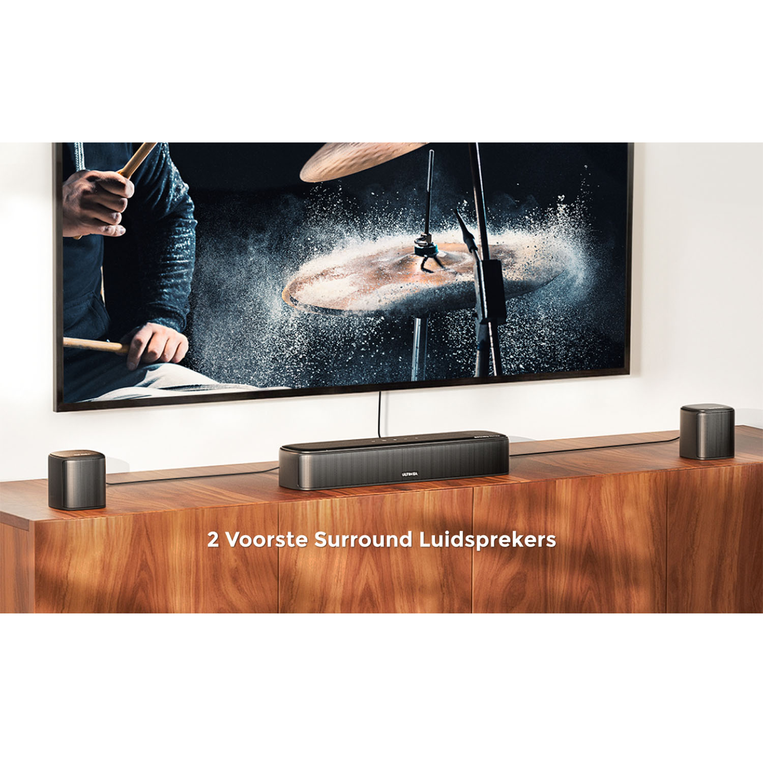 Geluidssysteem met luidsprekers en soundbar op een houten meubel met een tv op de achtergrond.