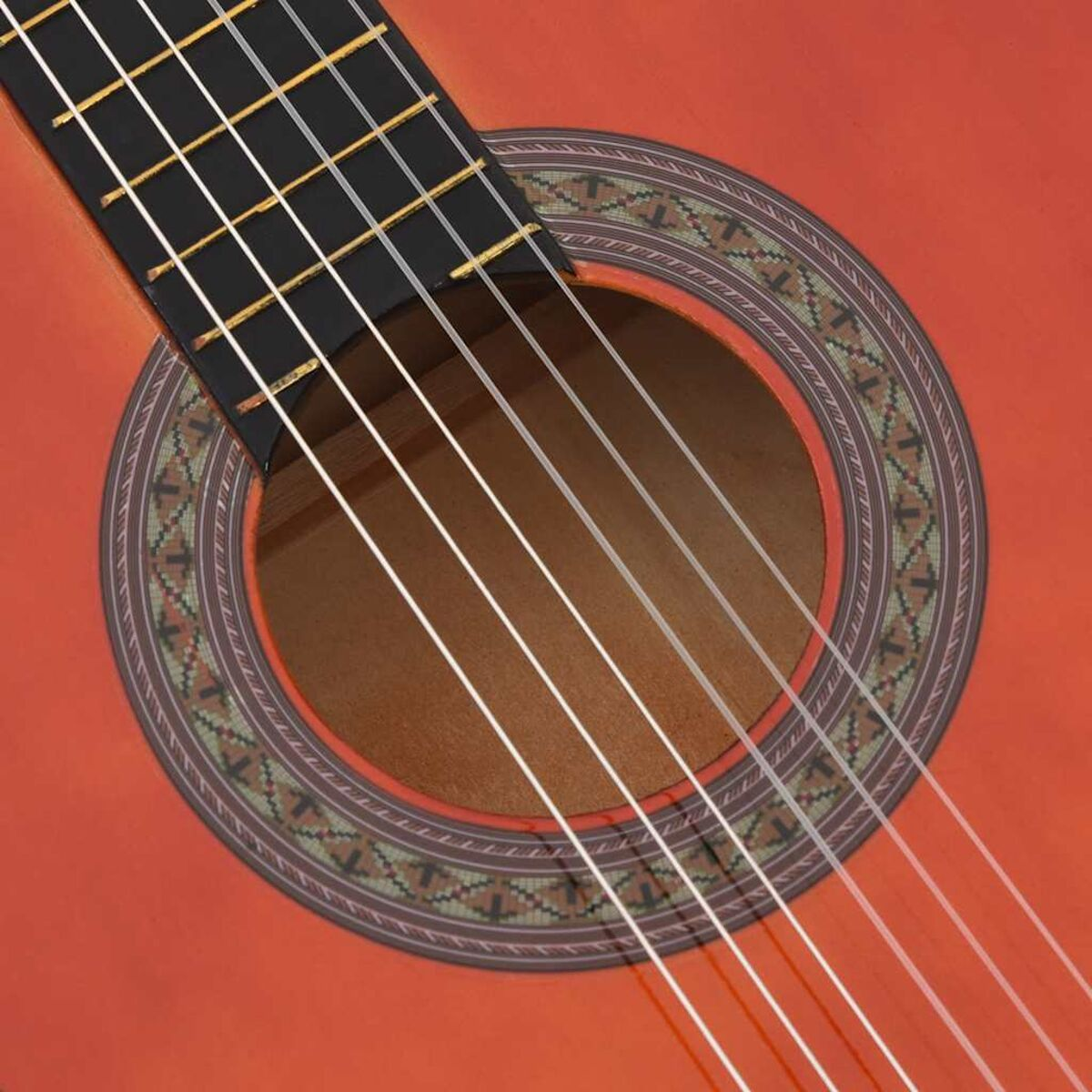 Nahaufnahme einer roten Akustikgitarre mit Saiten und Schallloch.
