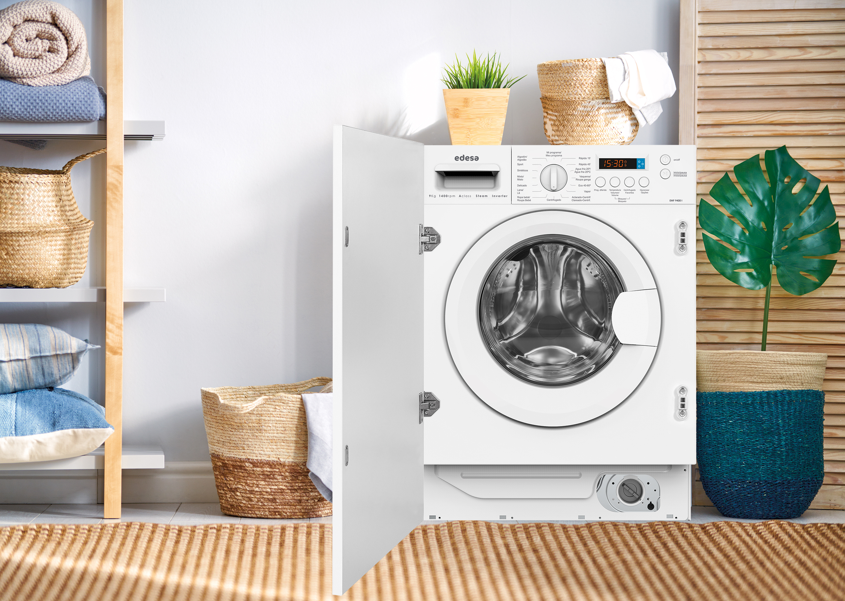 Lavadora empotrada blanca con la puerta abierta, con ropa y decoración. La habitación tiene detalles en madera.
