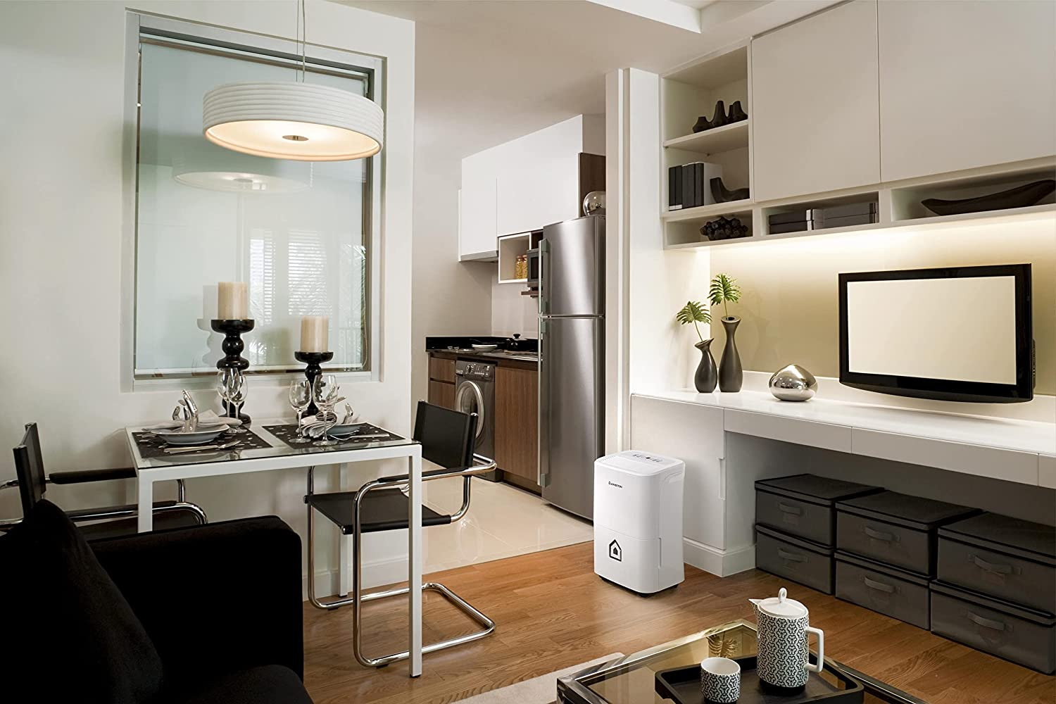 Salon z białym osuszaczem powietrza. Stół jadalny po lewej. Lodówka i biurko po prawej.