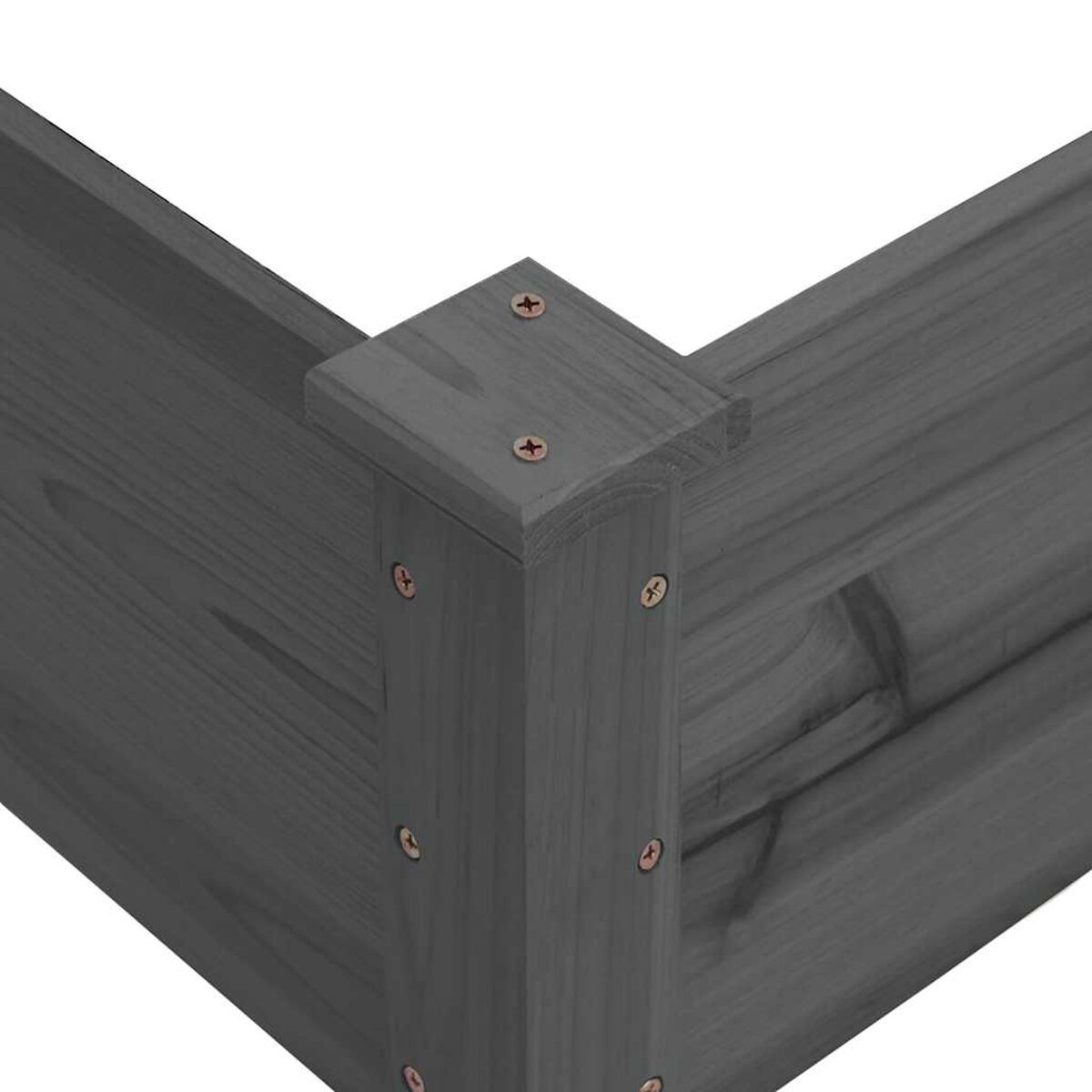 Nahaufnahme einer Holzecke eines erhöhten Gartenbeets. Das Holz ist grau, mit Schrauben an der Ecke.
