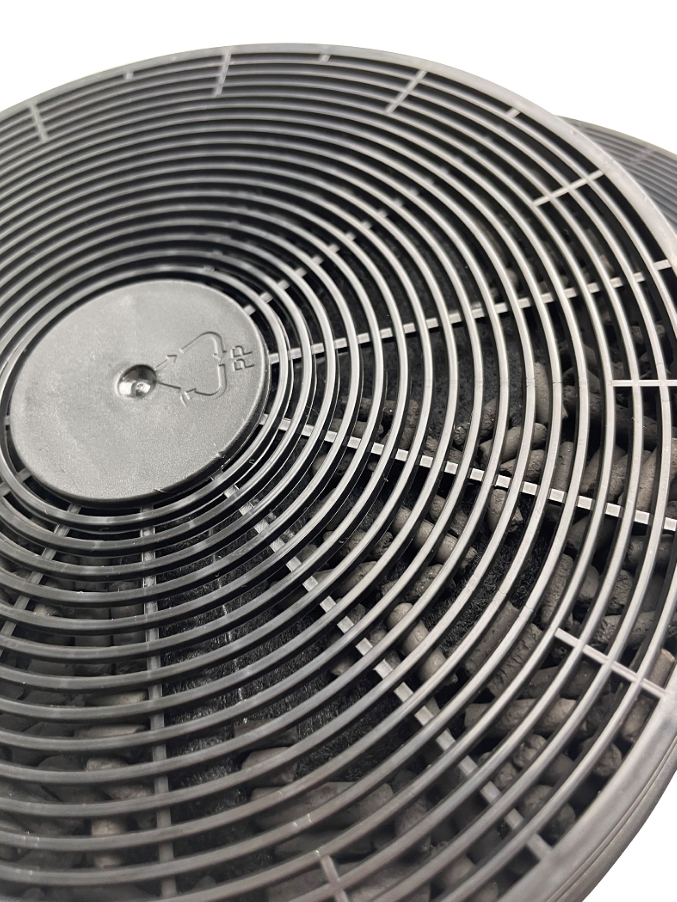 Close-up view of a carbon filter, showing the mesh and the filled granules with a plastic ring.
