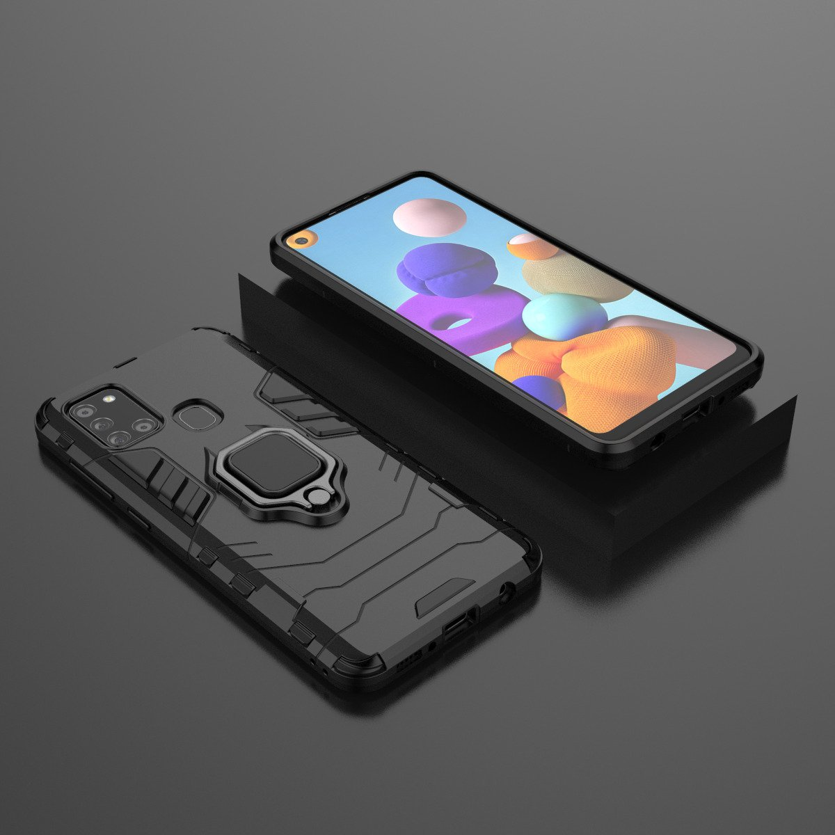 Dos teléfonos, uno con funda negra y anillo, otro con pantalla colorida, sobre una superficie oscura.