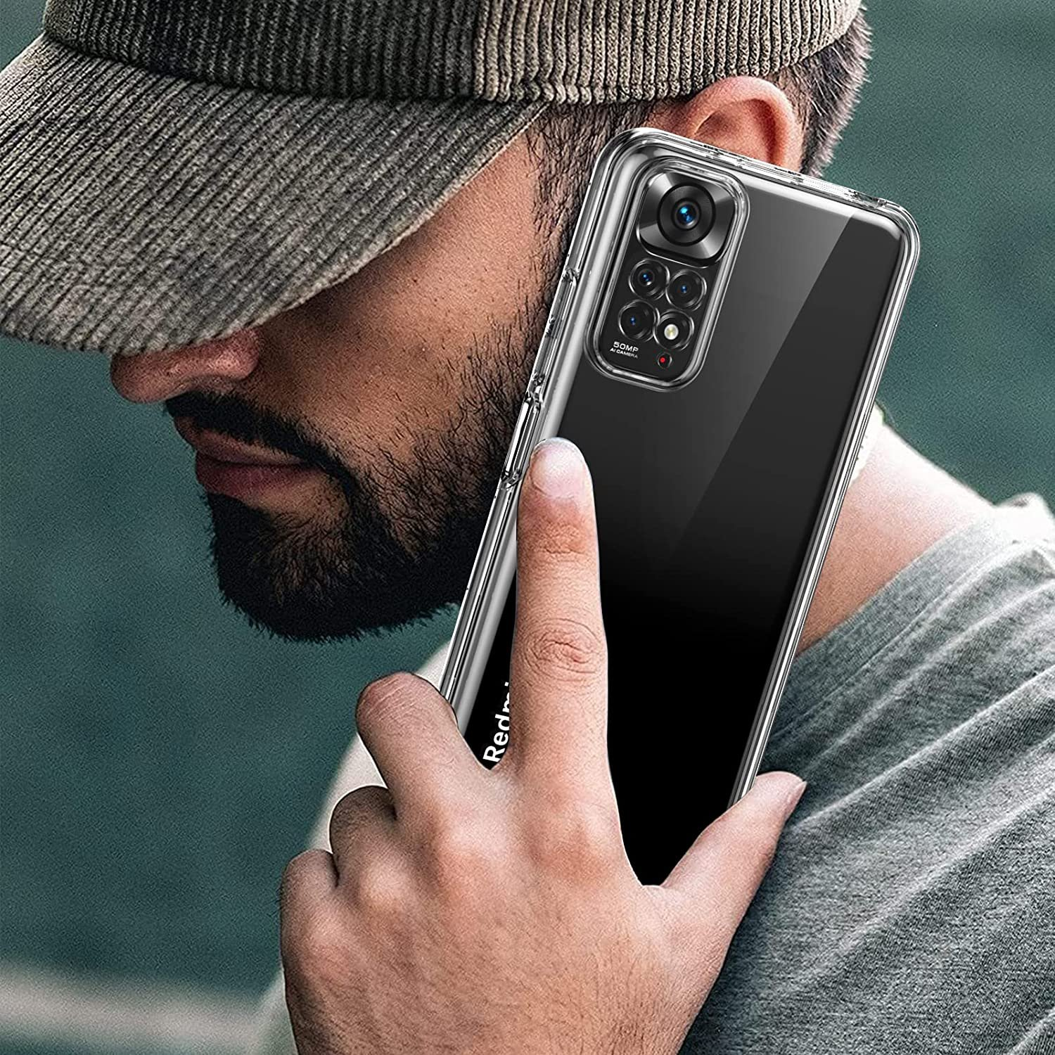 Un hombre sosteniendo un teléfono en una funda transparente. El teléfono tiene una cámara triple. El fondo está borroso.