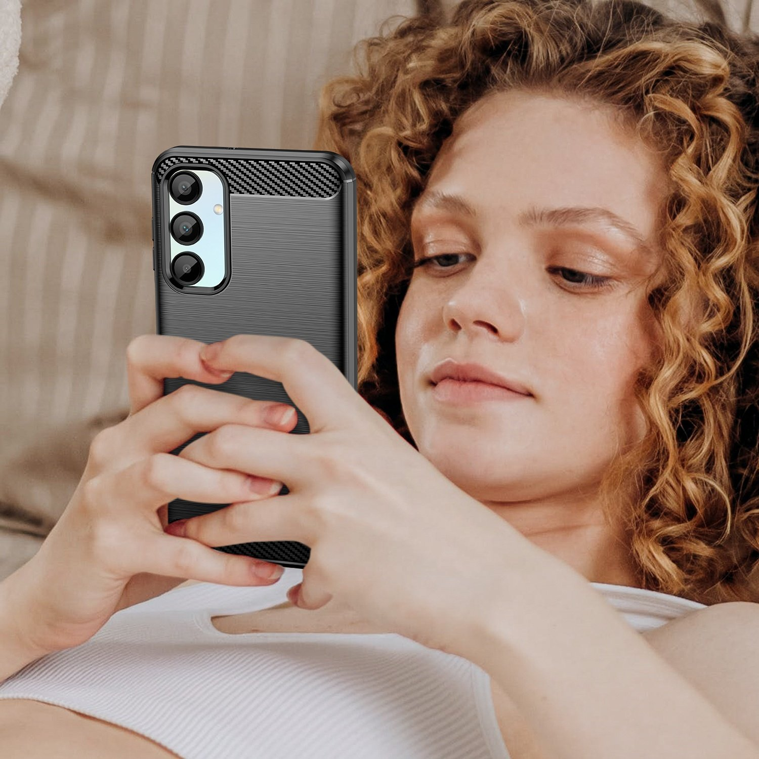 Mujer sosteniendo un teléfono con una funda negra. El teléfono tiene una funda negra con la parte trasera texturizada.