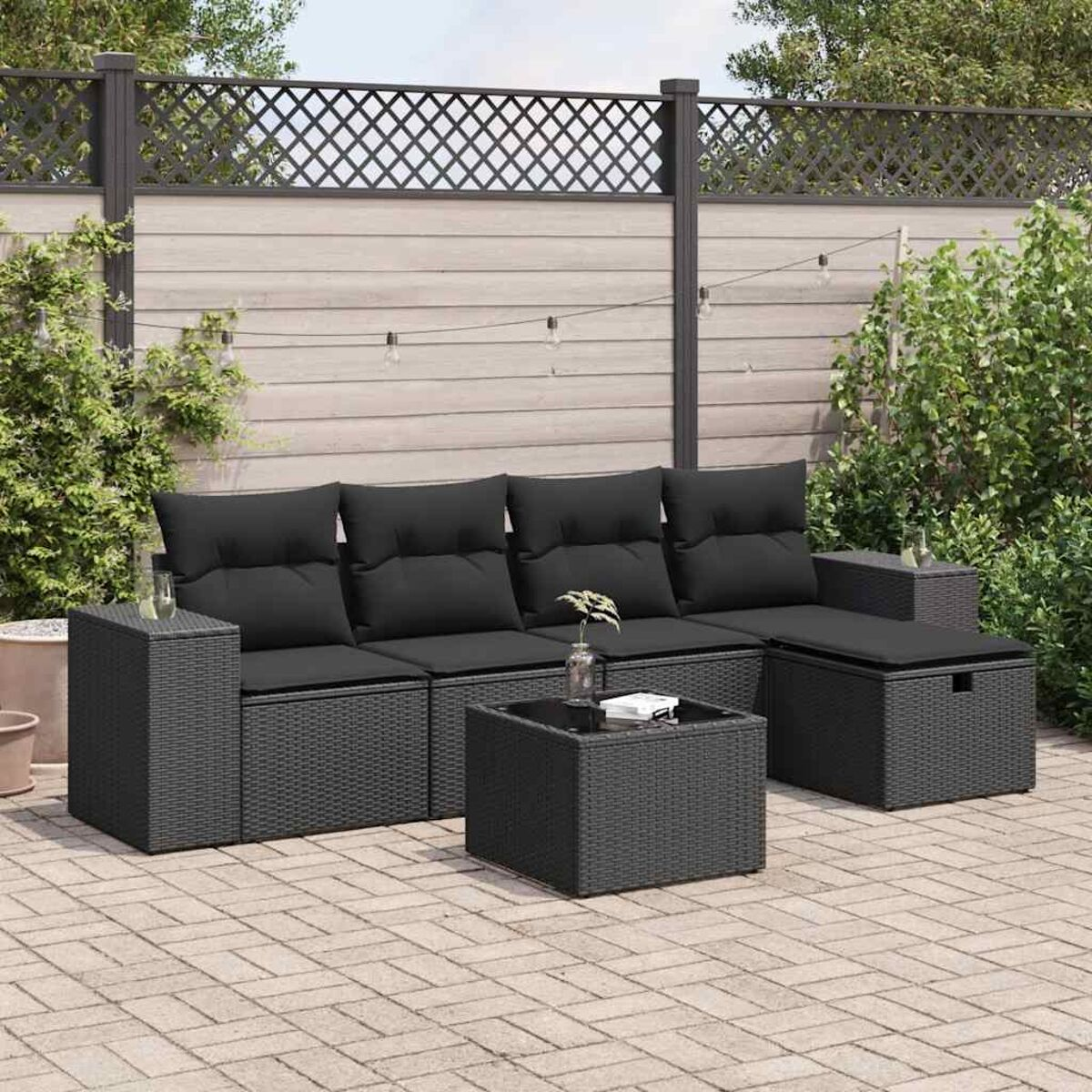 Set di mobili da esterno in rattan nero con cuscini e un tavolino.