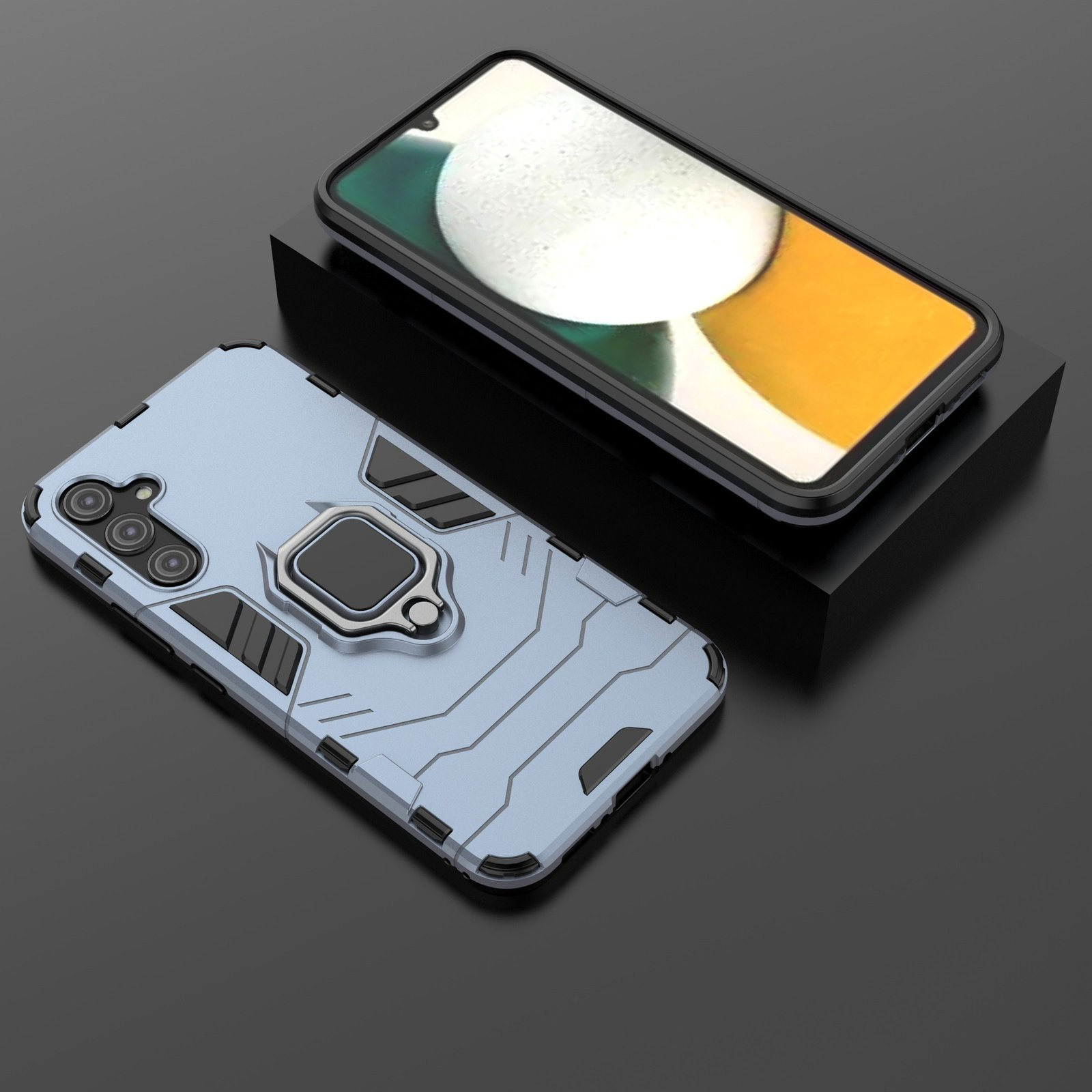 Funda de teléfono con teléfono. Funda azul-gris con soporte de anillo. Teléfono con pantalla amarilla y blanca. Sobre una superficie negra.