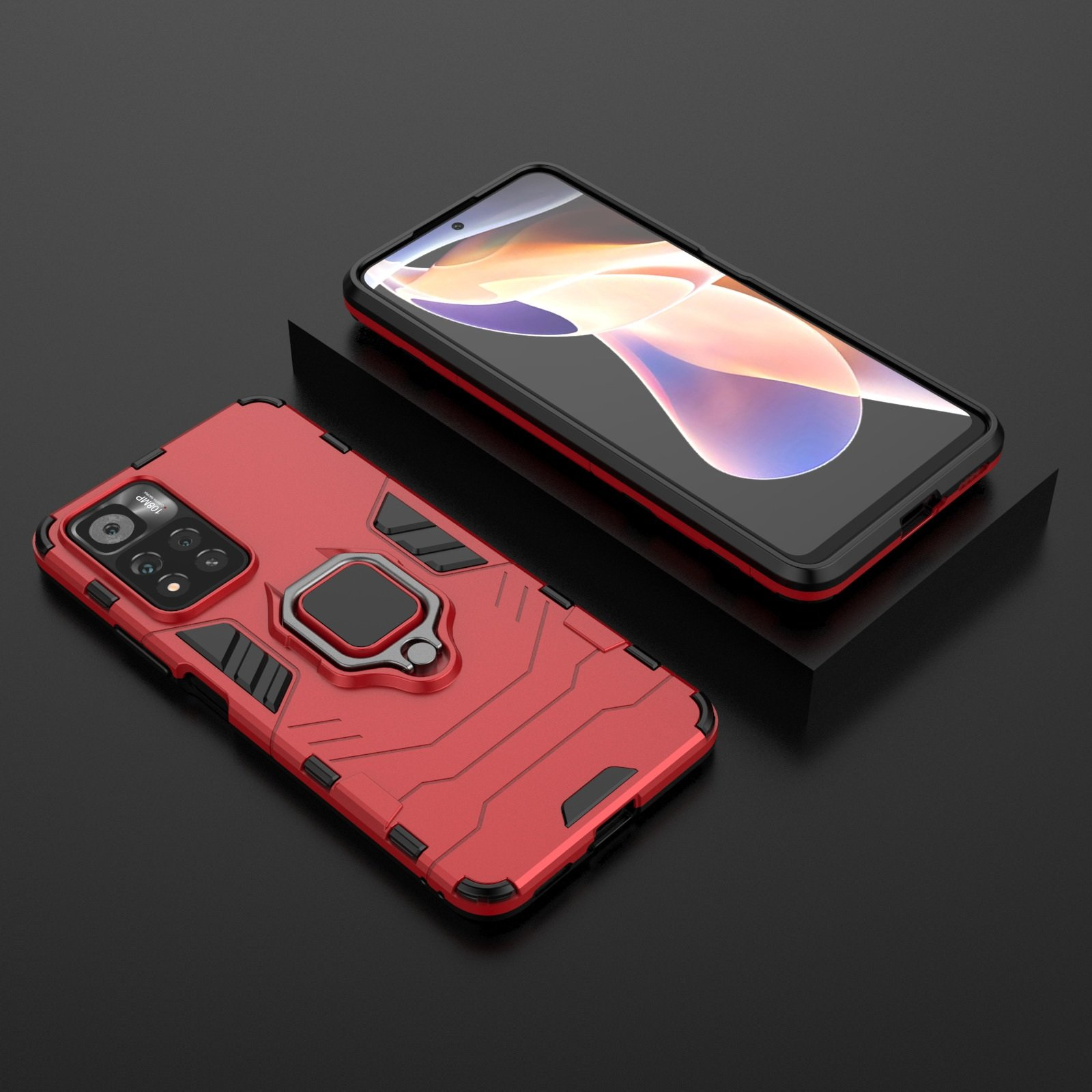 Funda roja con anillo y un teléfono con funda negra, sobre una superficie.