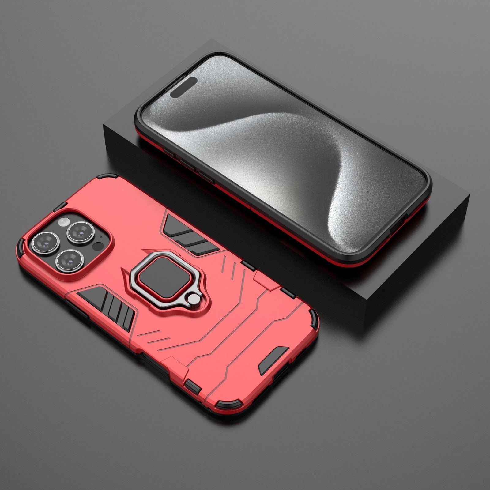 Una funda roja para teléfono con soporte de anillo sobre superficie negra, junto a un teléfono con pantalla.
