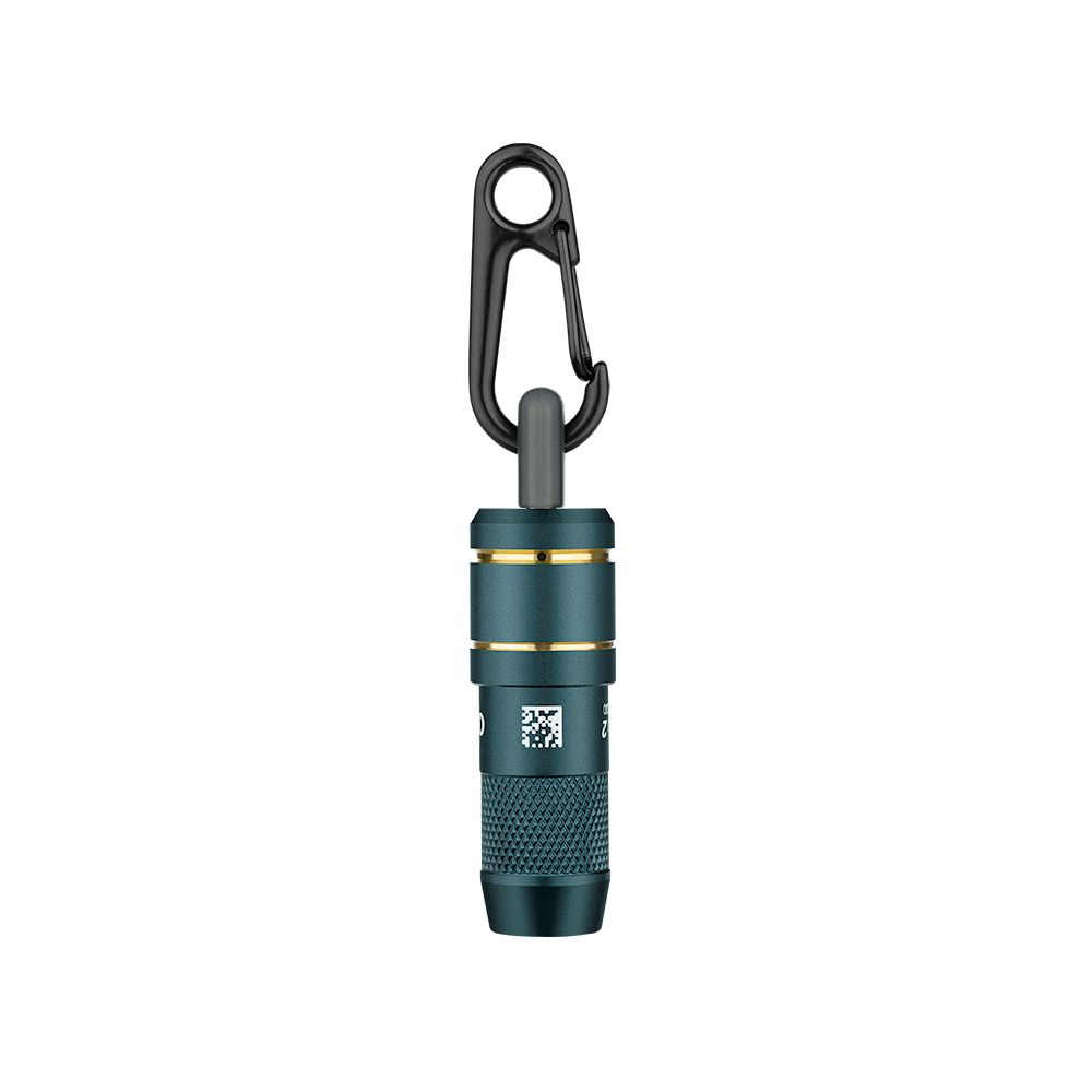 Un objeto cilíndrico pequeño, verde azulado, con un clip negro. El objeto tiene un anillo plateado y un código QR.