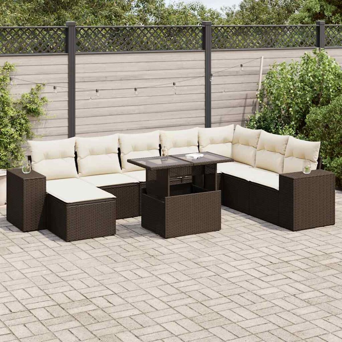 Ein modernes Outdoor-Rattan-Möbelset mit Tisch und Ecksofa mit cremefarbenen Kissen.