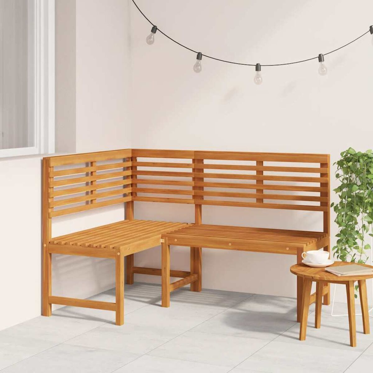 Eckbank aus Holz mit kleinem Beistelltisch und Lichterkette, im Freien.