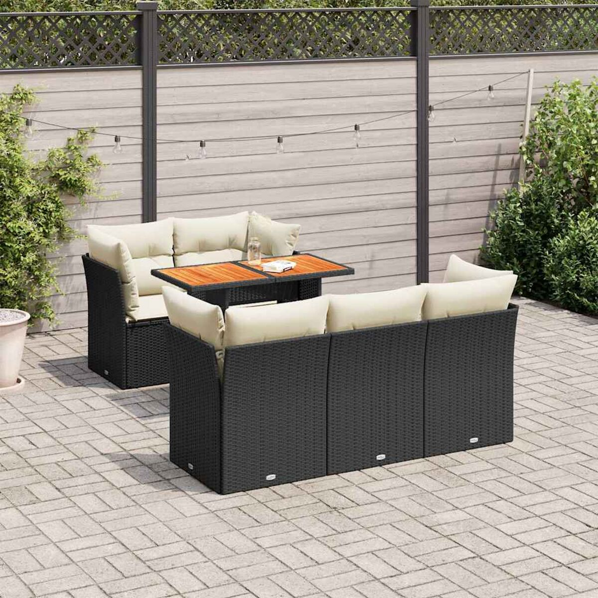 Set divani da esterno con tavolo e due divani. Vimini nero e cuscini beige.