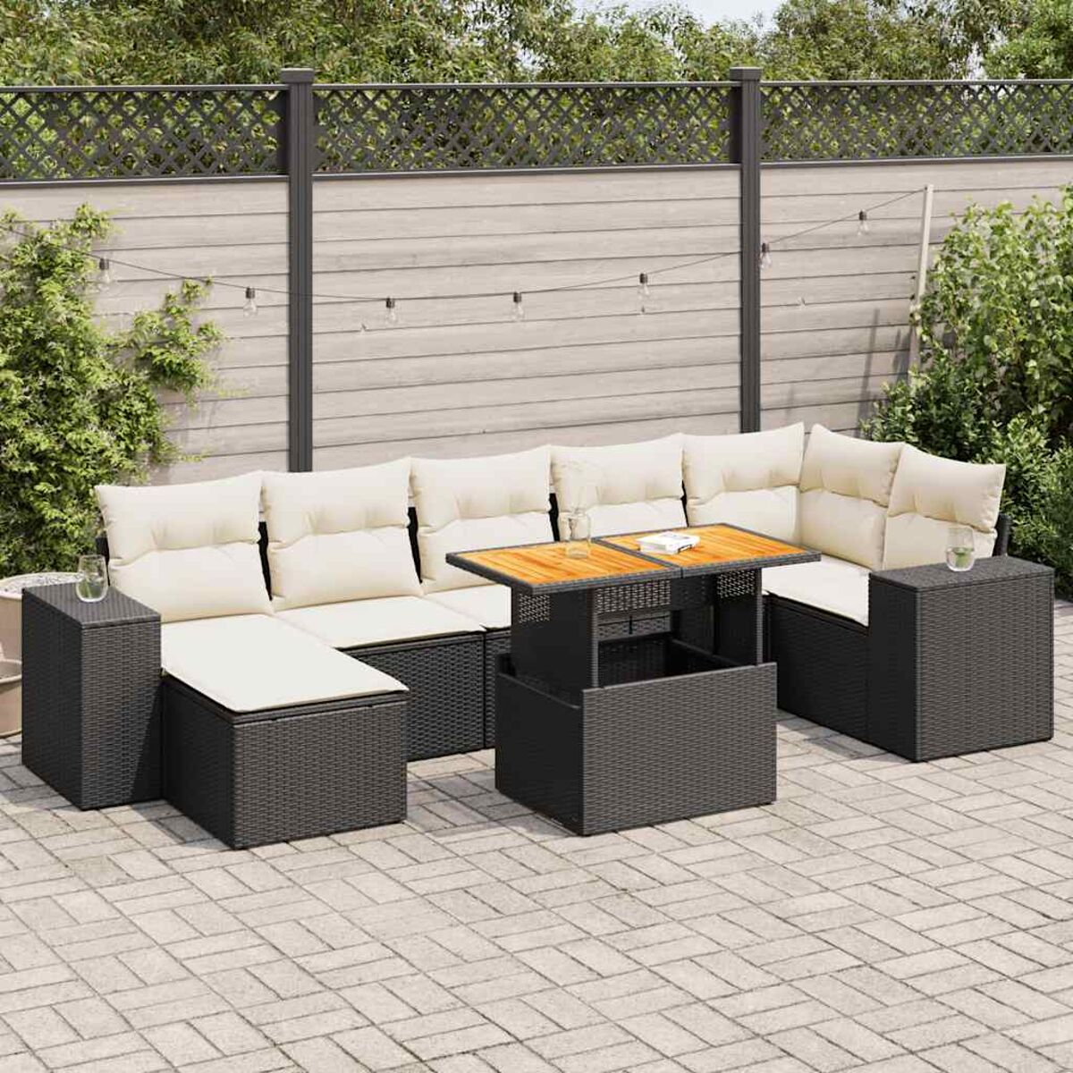 Divano componibile da esterno con cuscini e tavolo sollevabile su patio pavimentato.
