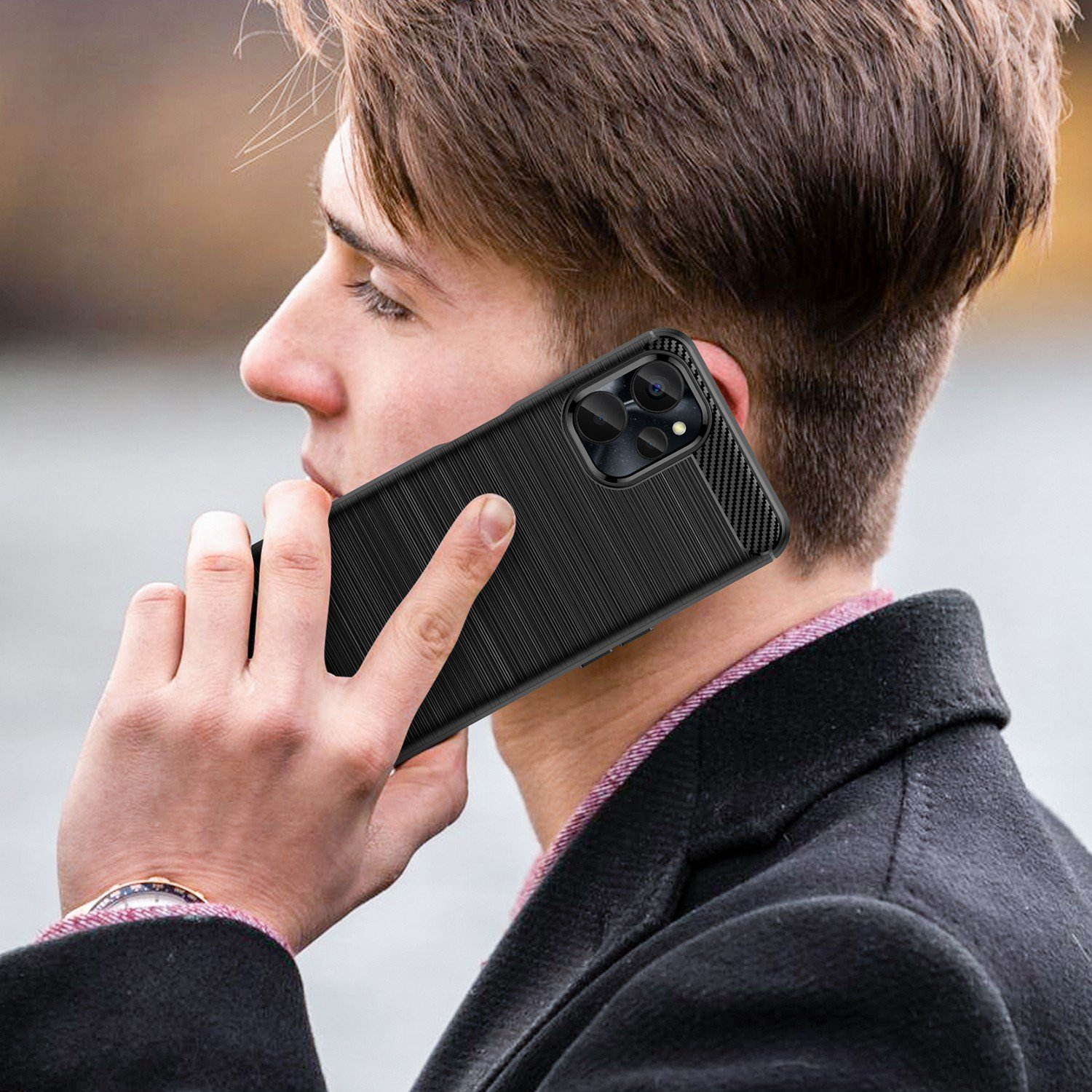 Un hombre sostiene un teléfono negro en su oído. El teléfono tiene una funda negra texturizada.