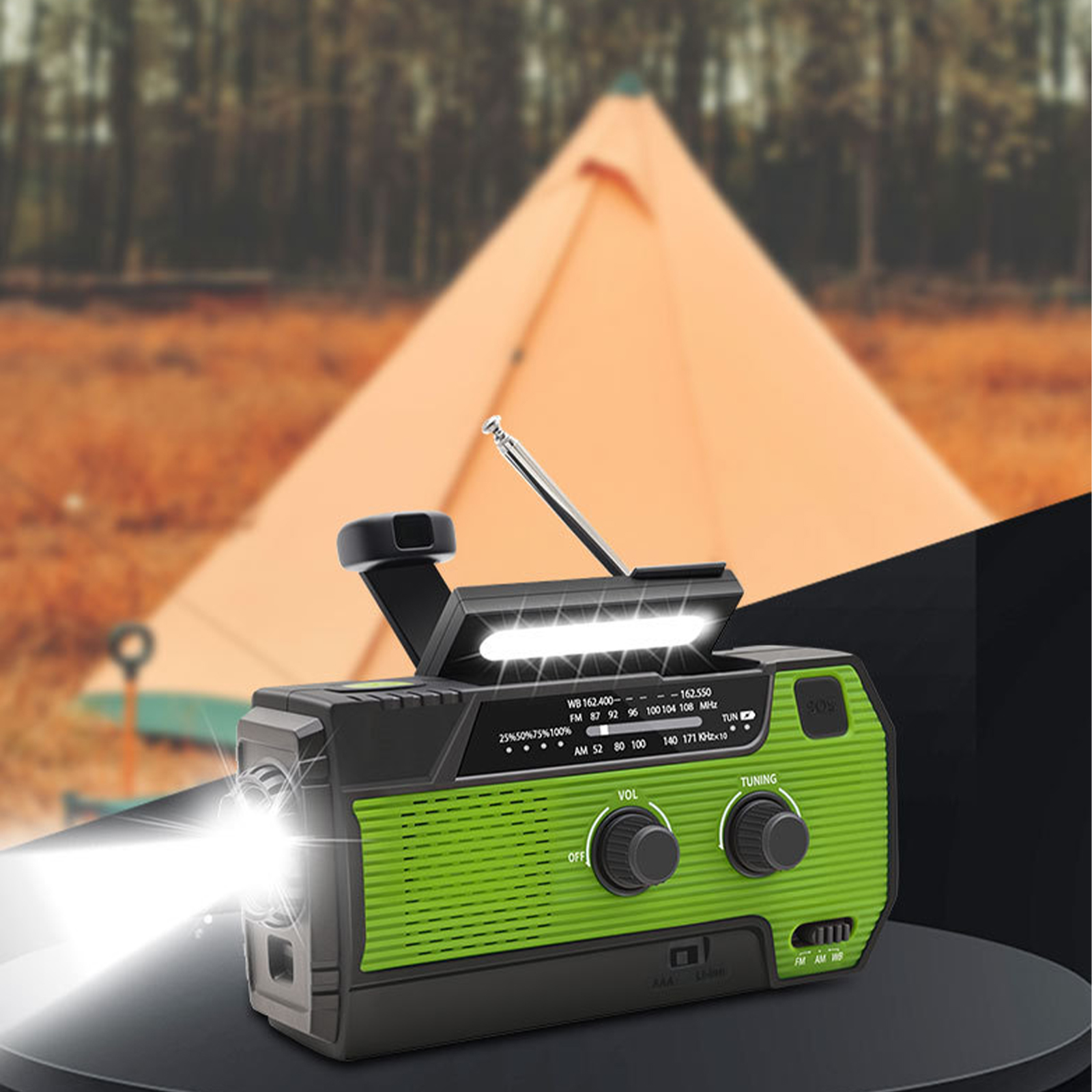Grünes und schwarzes Handkurbelradio mit Taschenlampe, die in einer Waldszene scheint.