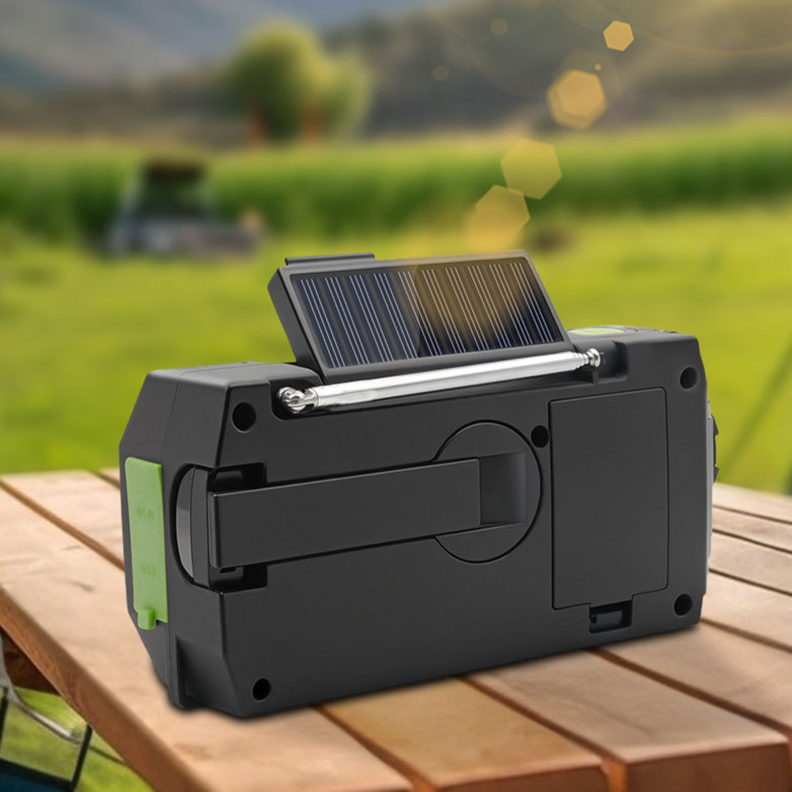 Schwarzes solarbetriebenes Radio auf einem Holztisch. Es hat ein kleines Solarpanel und einen Griff. Grüner Hintergrund.