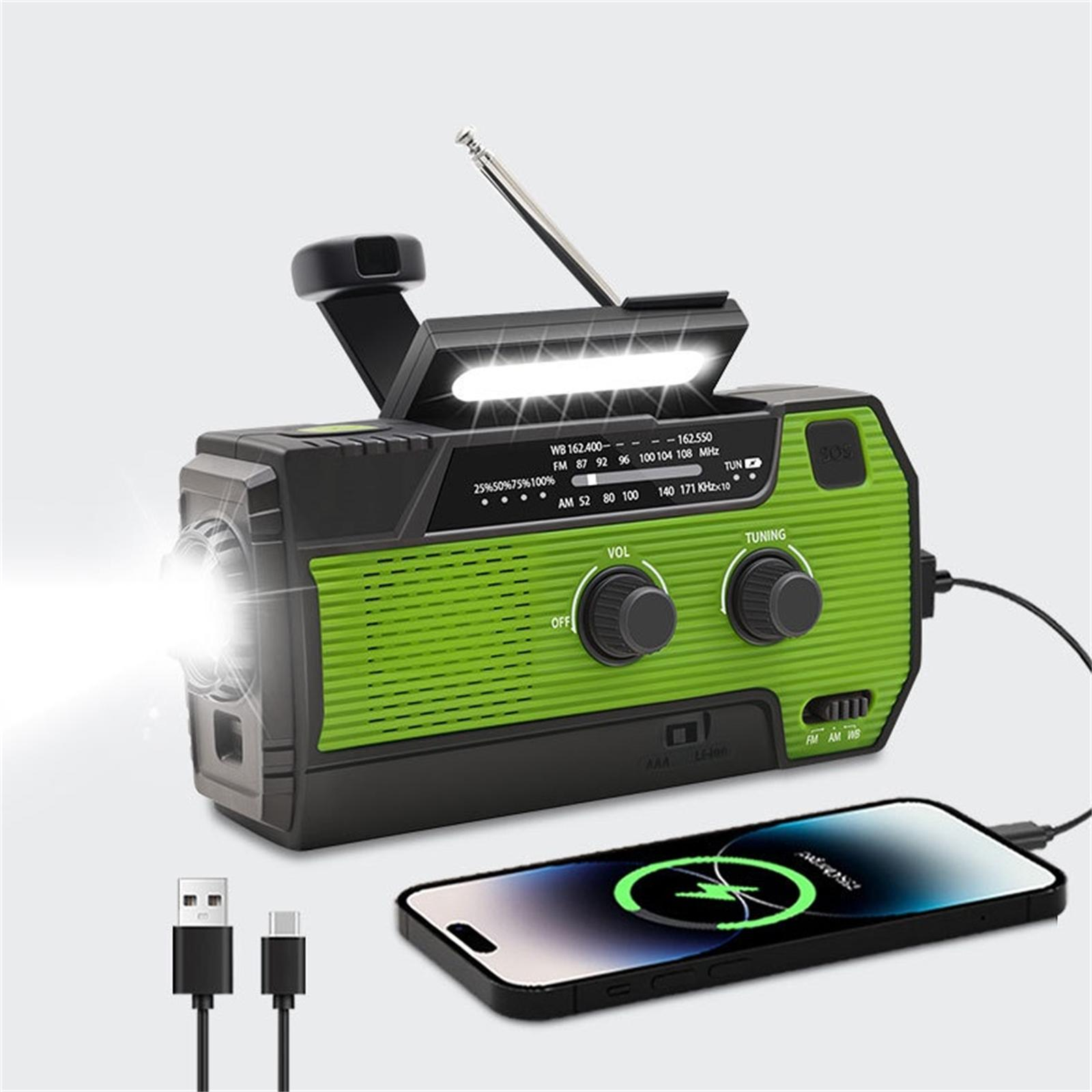 Grünes und schwarzes Kurbelradio. Enthält eine Taschenlampe, einen Ladeanschluss und USB-Kabel. Ein Telefon lädt.