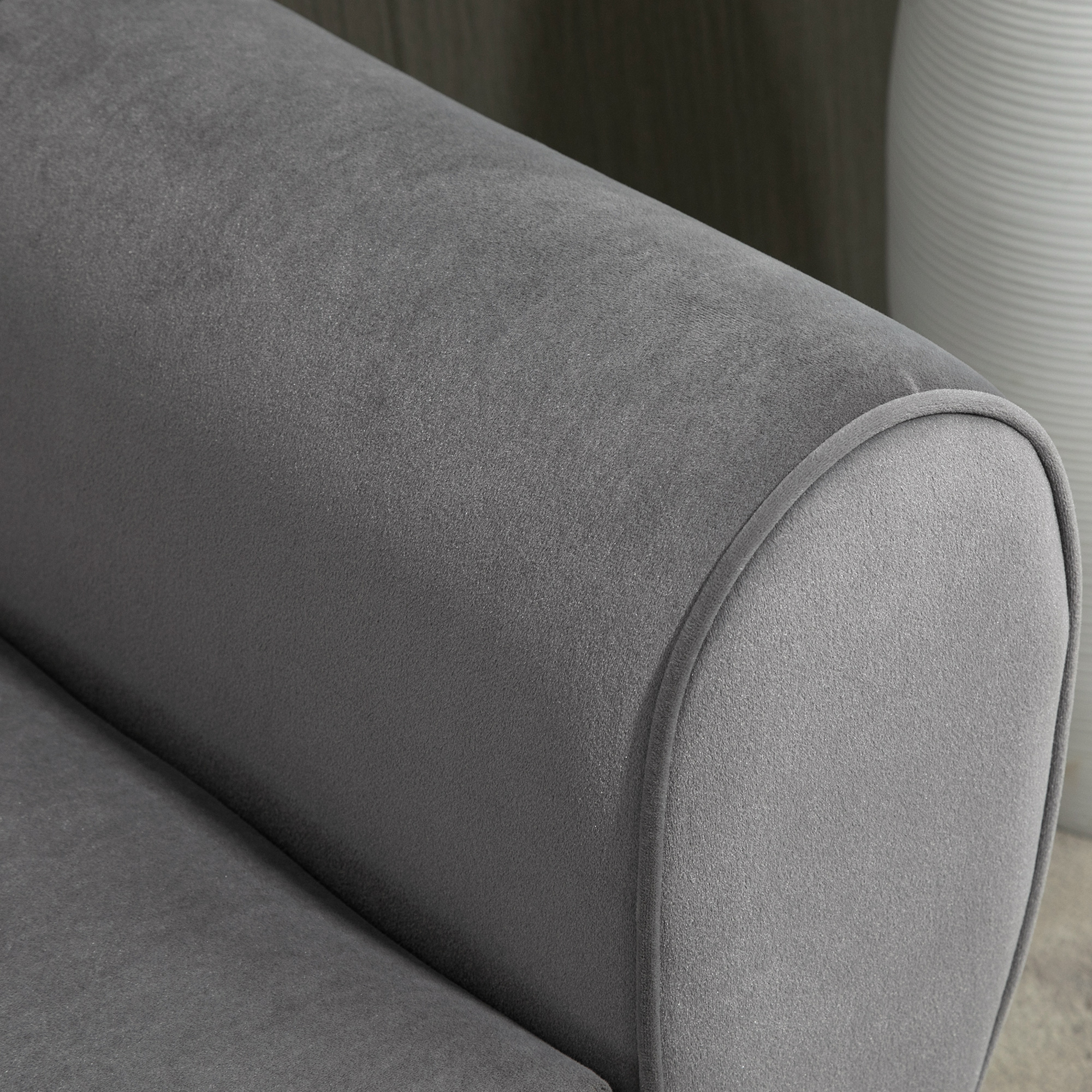 Nahaufnahme einer grauen Stoffarmlehne eines Sofas. Gebogene Form.