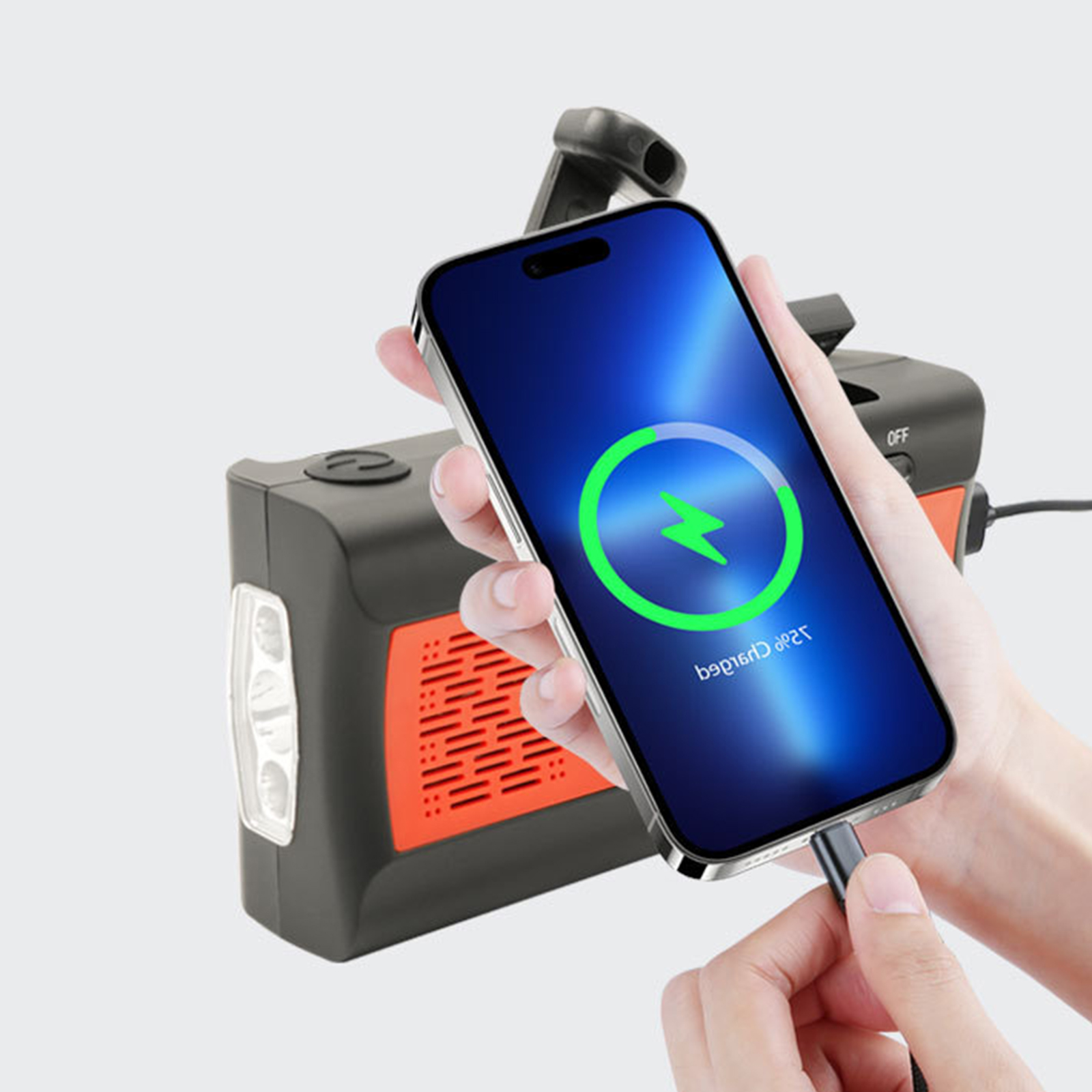 Telefon wird kabellos mit einer orangefarbenen und schwarzen tragbaren Powerbank geladen.