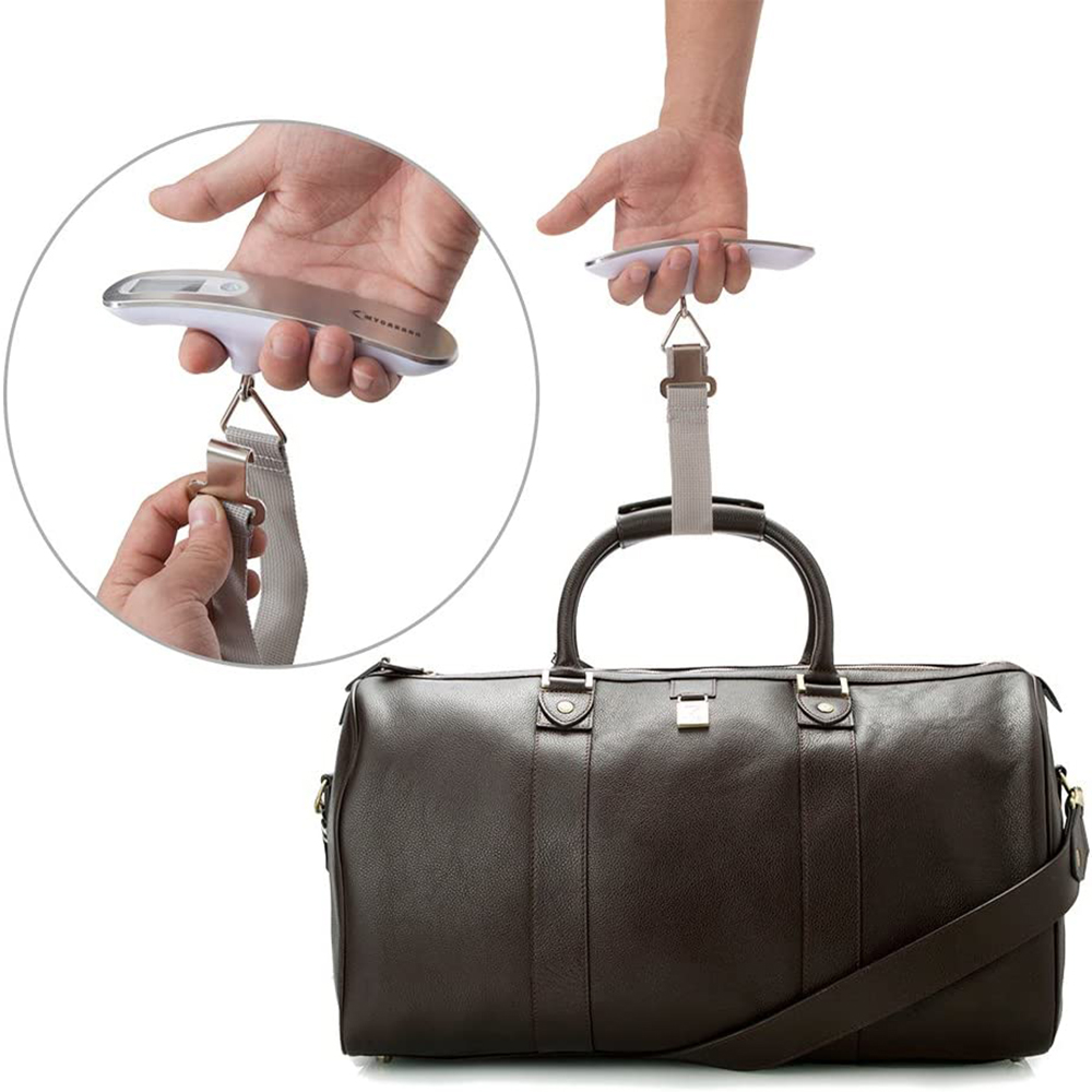 Person hält eine Gepäckwaage und befestigt sie an einer braunen Ledertasche.