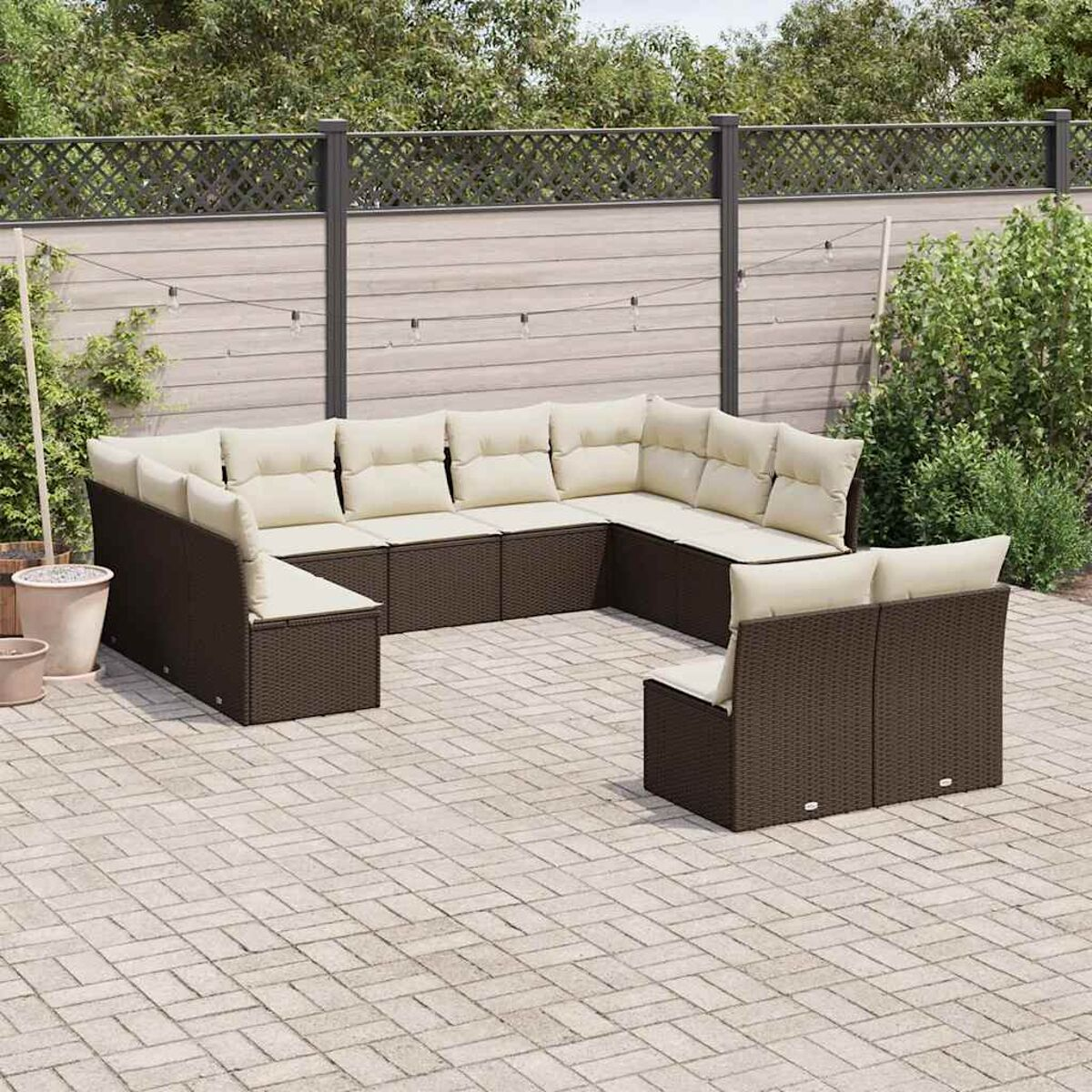 Gartenmöbel-Set auf einer Terrasse mit Zaun und Pflanzen.