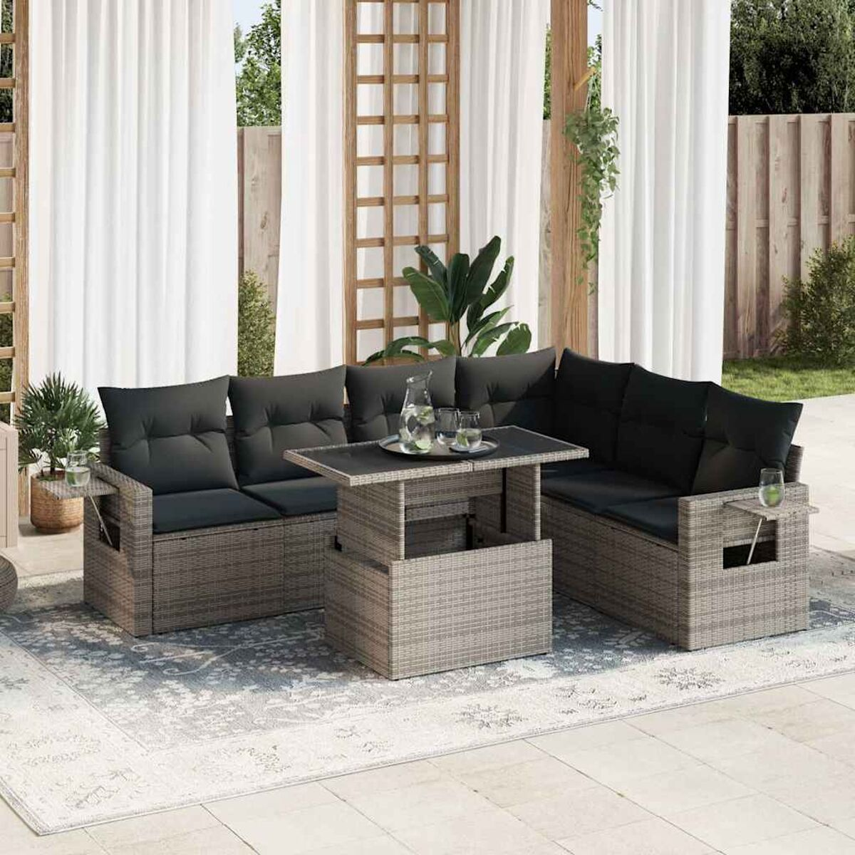 Gartenset mit grauen Kissen, Hebetisch und Vorhängen im Hintergrund.