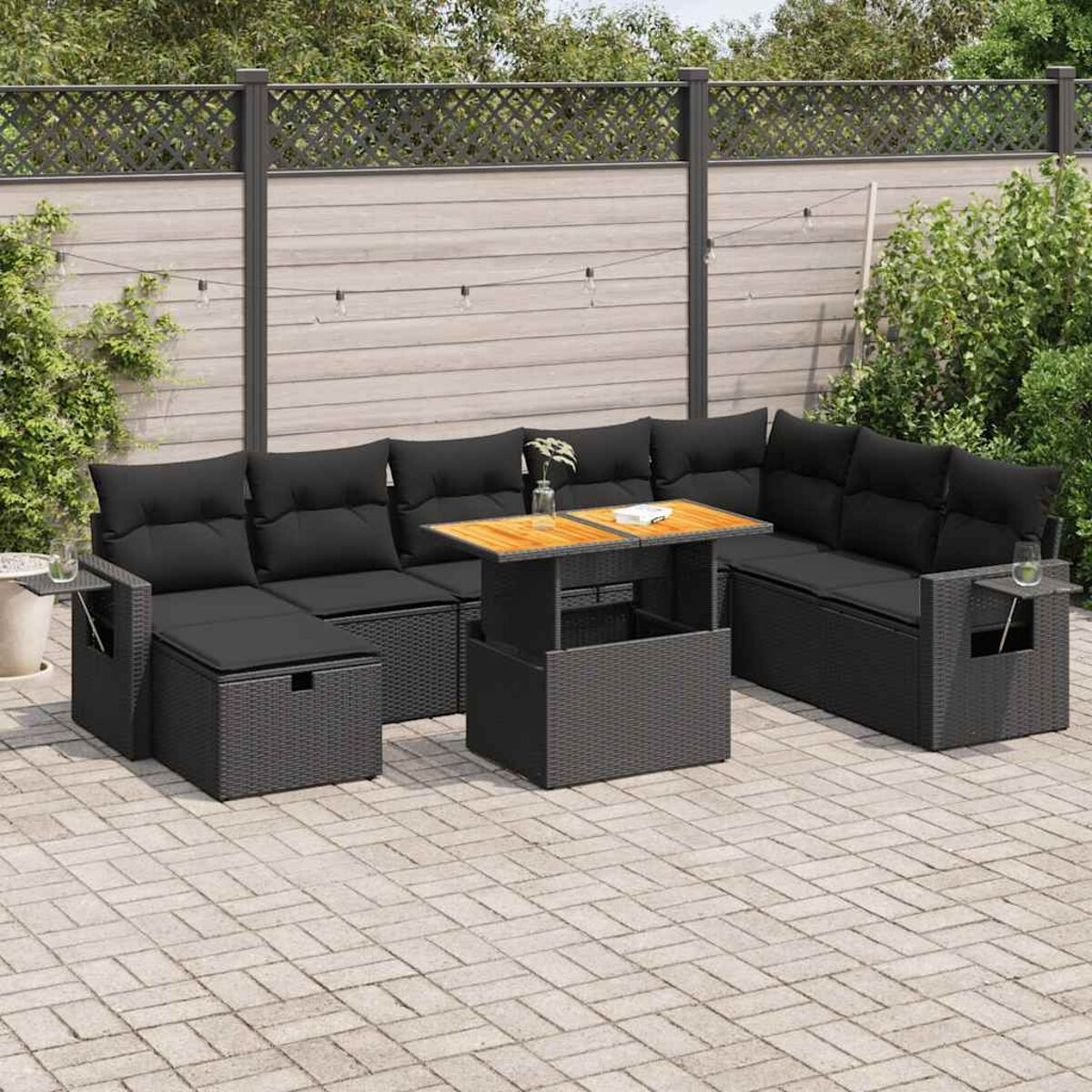 Set di mobili da patio per esterni. Include un divano angolare, un tavolo e una panca, con cuscini neri e tavolo in legno.