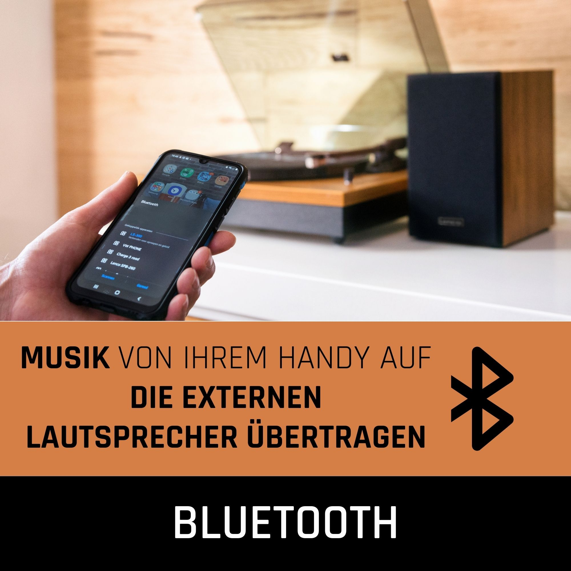 Smartphone zeigt Musik-App. Plattenspieler und Lautsprecher im Hintergrund. Bluetooth-Verbindung.