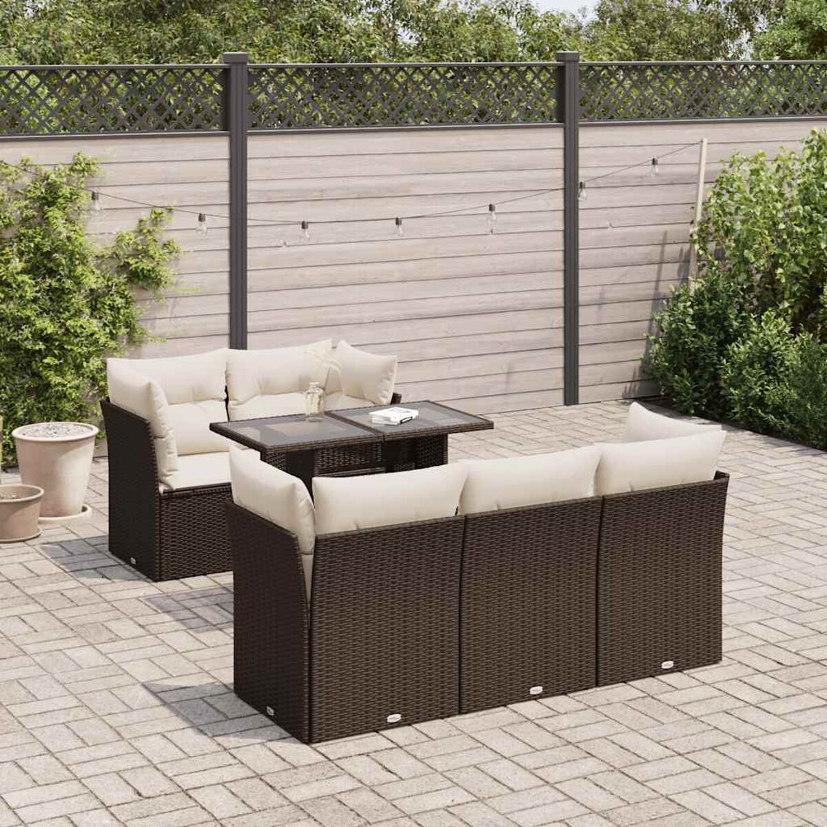 Juego de muebles de patio exterior con una mesa y sillas, rodeado por una valla.