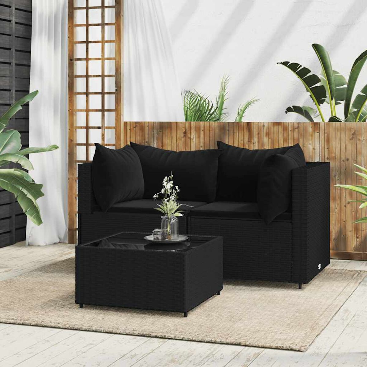 Schwarzes Outdoor-Terrassenset mit Sofa und Couchtisch, auf einem neutralen Teppich.