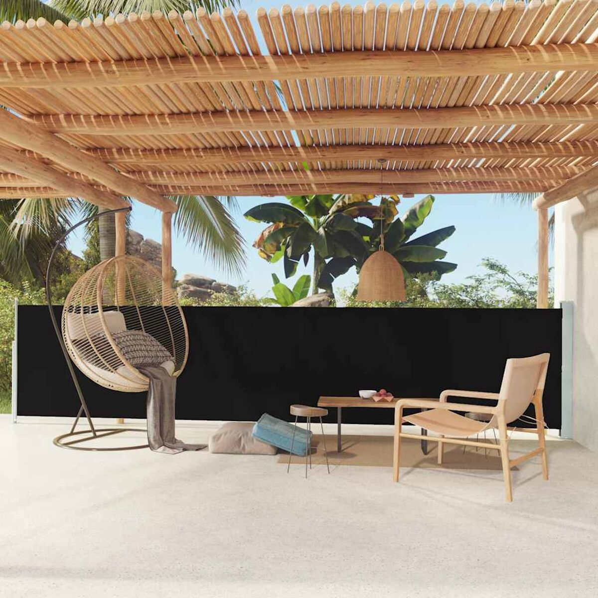 Terrasse im Freien mit schwarzem Sichtschutz. Ein Hängesessel, Tisch und Stuhl sind vorhanden.