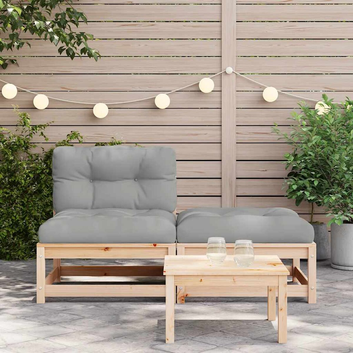 Holz-Outdoormöbelset mit zwei Sitzen, einem kleinen Tisch und Lichterketten auf der Terrasse.