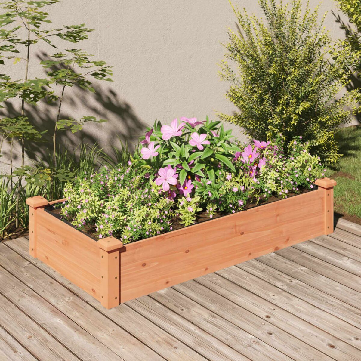 Eine hölzerne Pflanzkasten mit rosa Blumen und grünen Pflanzen auf einem Holzdeck mit Pflanzen im Hintergrund.