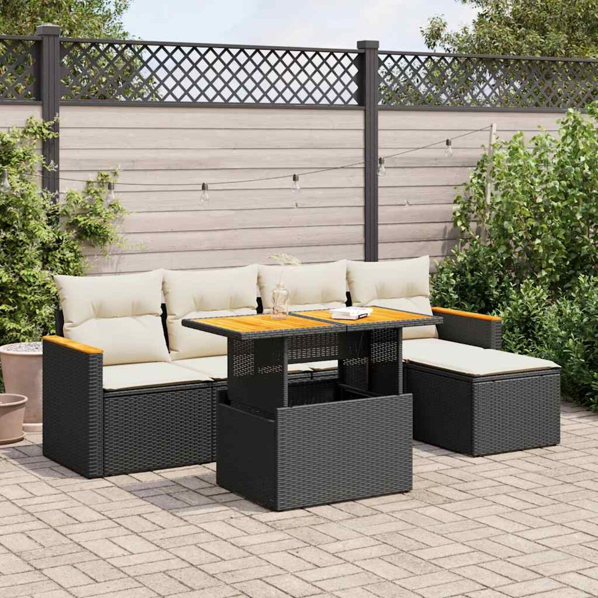 Viene mostrato un set da patio nero con un tavolo, cuscini e un tappeto.