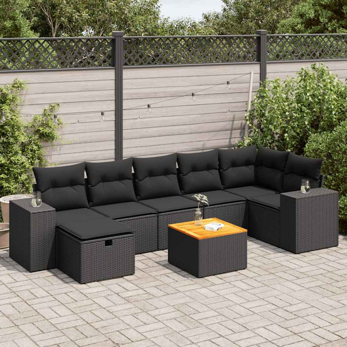 U-förmige Rattan-Sofaanordnung mit schwarzen Kissen und einem Couchtisch.