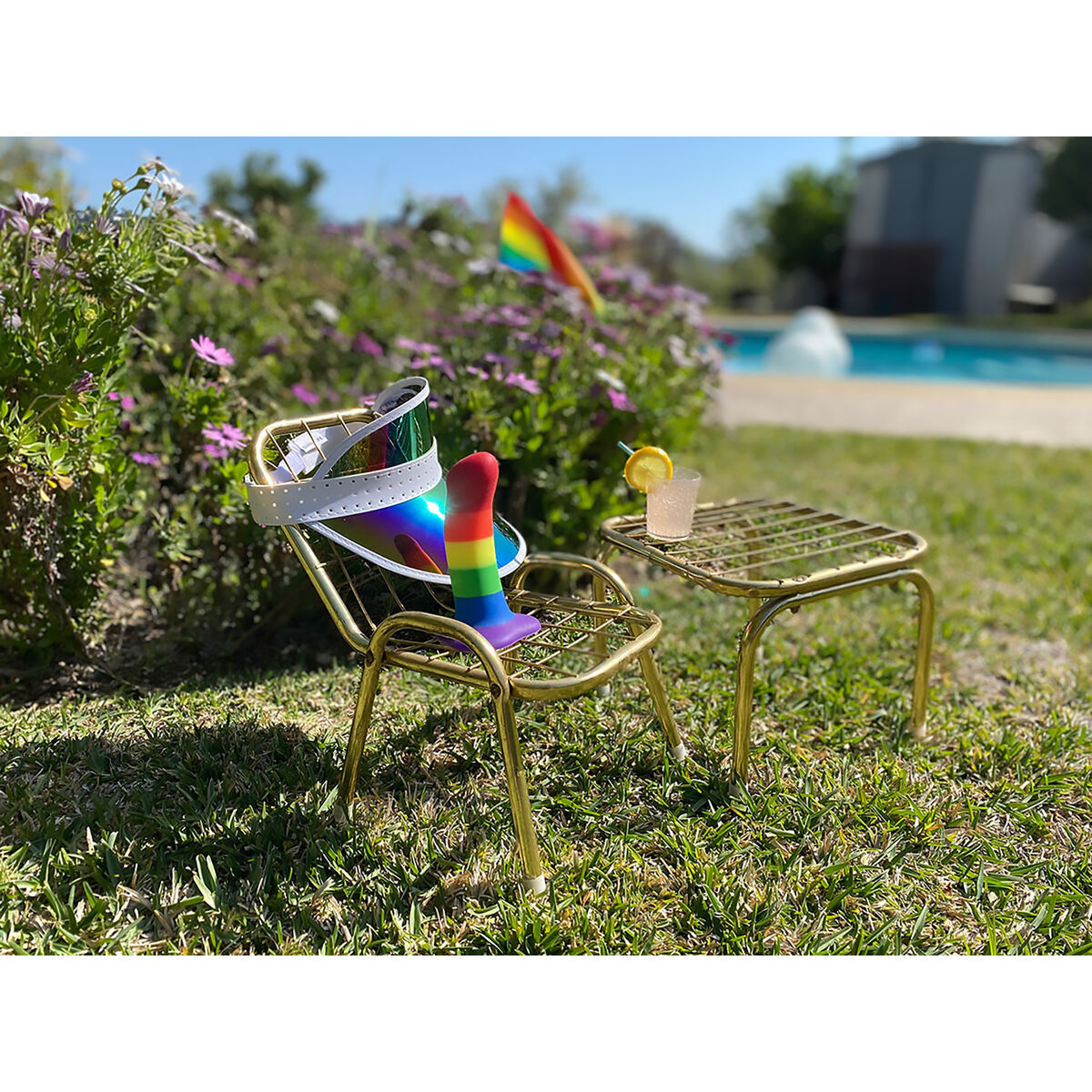Scena w ogrodzie z krzesłem, koktajlem i tęczowym przedmiotem.