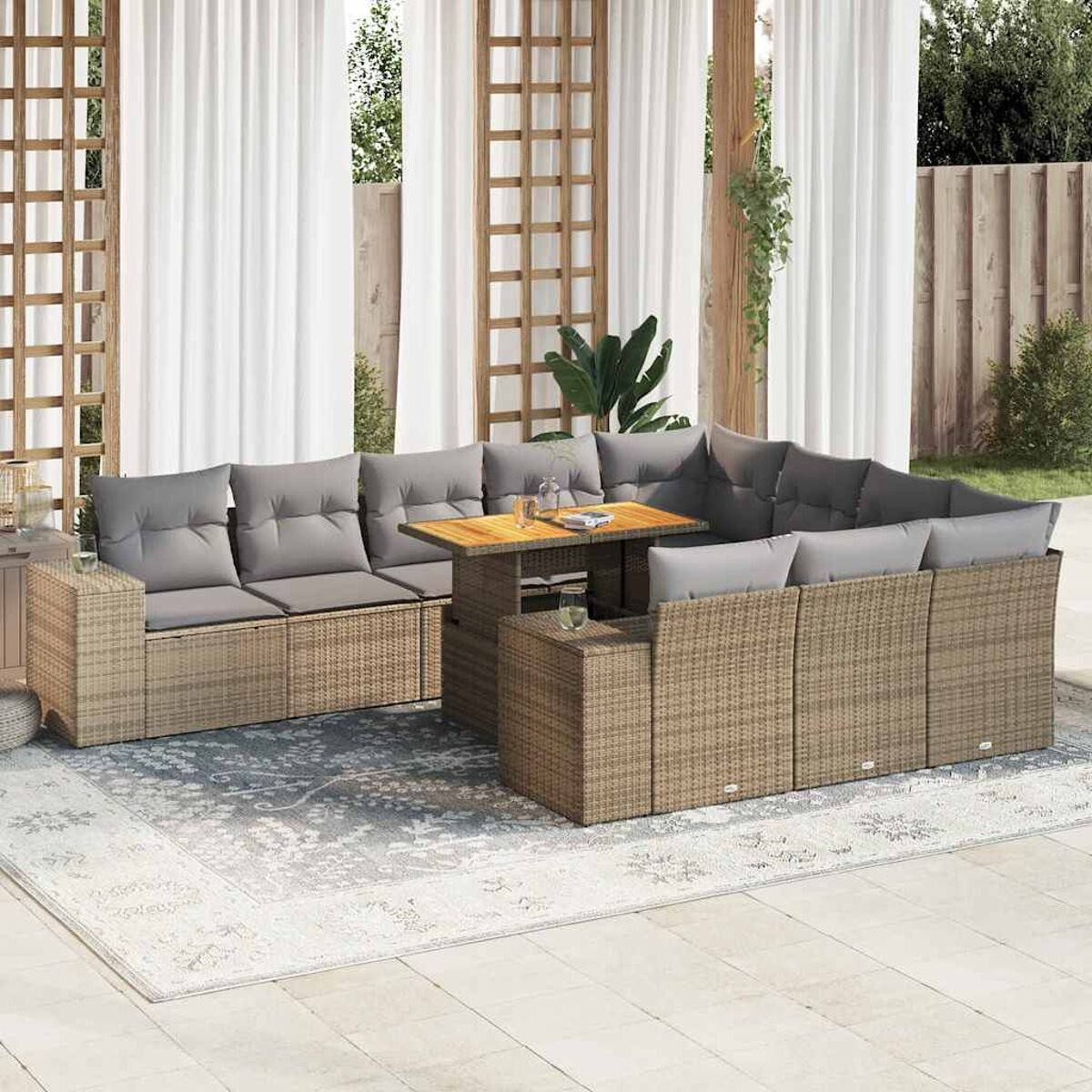 Set divani in rattan da esterno con cuscini grigi e tavolo in legno su un tappeto.