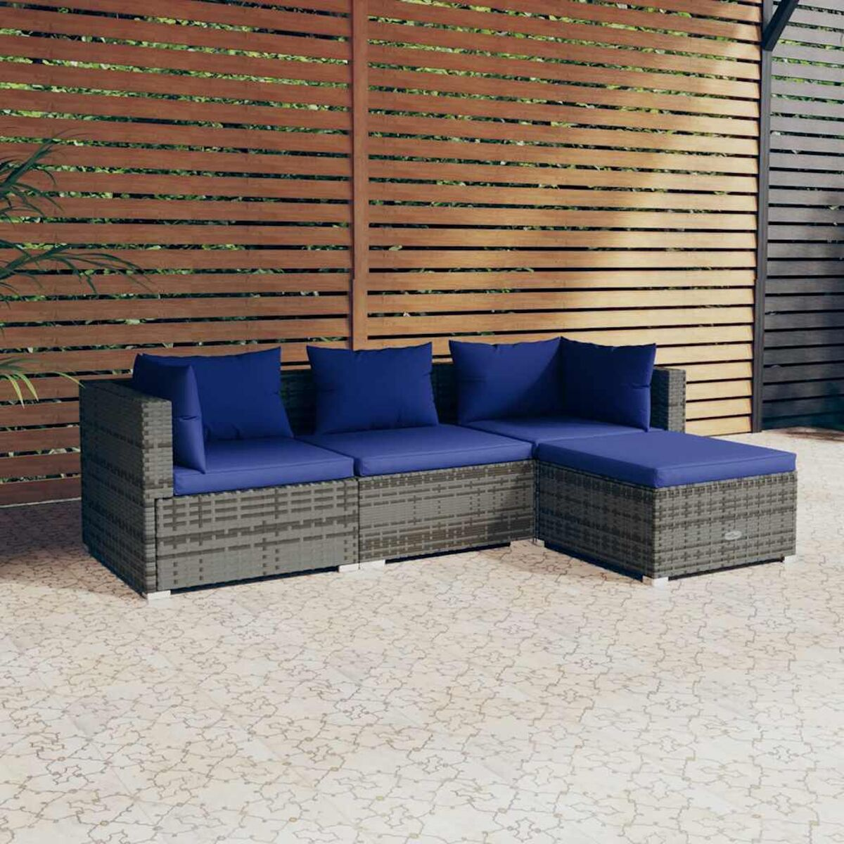 Graues Outdoor-Sofa mit blauen Kissen. Holzzaun im Hintergrund. Fliesenboden.