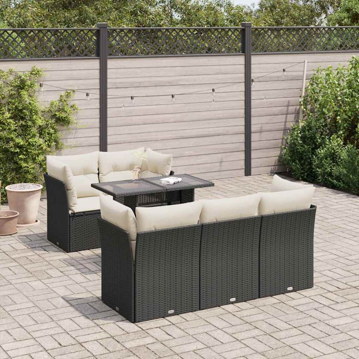 Set di mobili da esterno. Un set di divani in rattan grigio con tavolo, cuscini e recinzione.